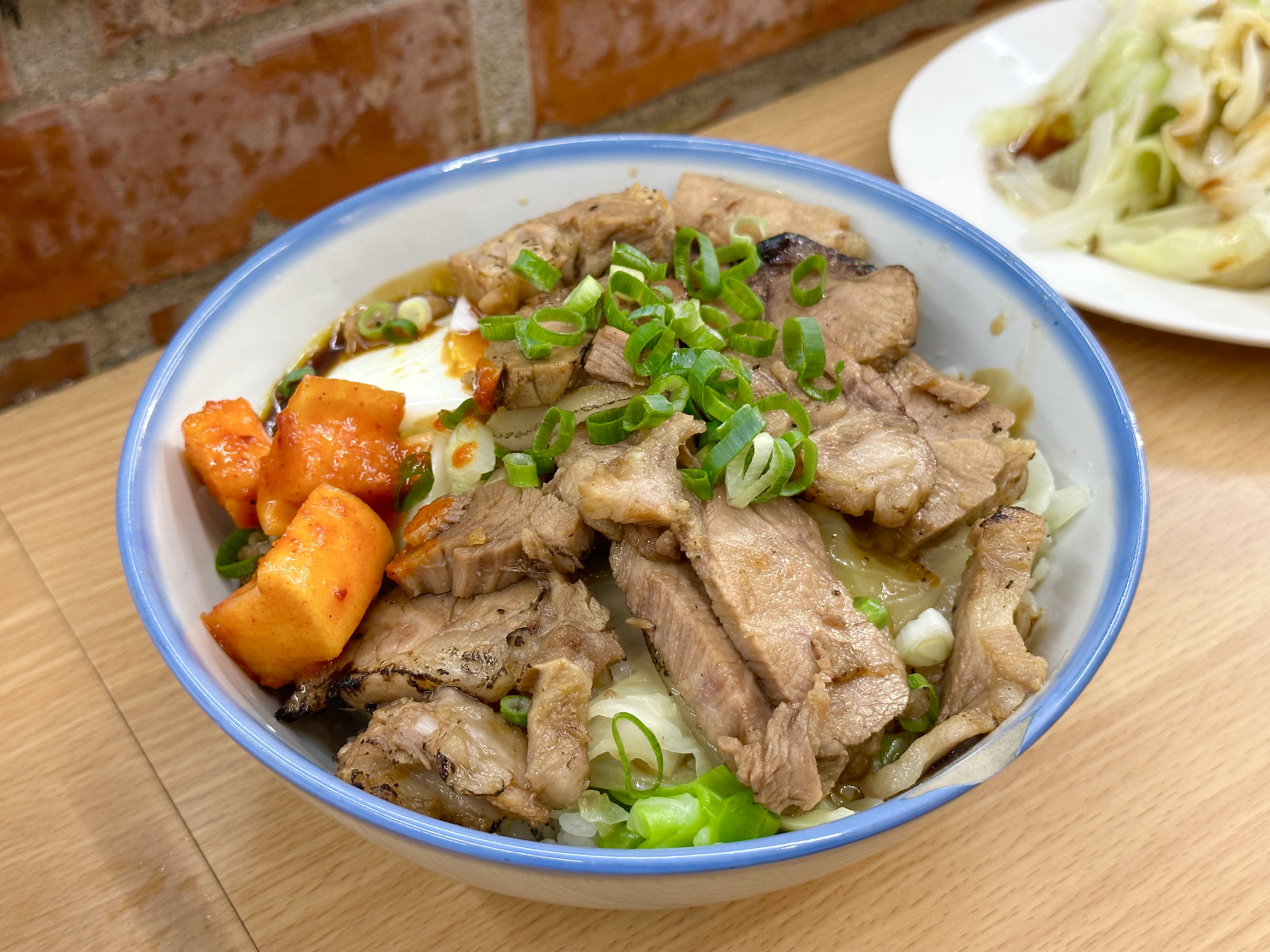「火燒骨仔肉飯」分量十足，不只鋪滿骨仔肉，還有高麗菜、半熟蛋與醃蘿蔔，很有飽足感。（120元／份）