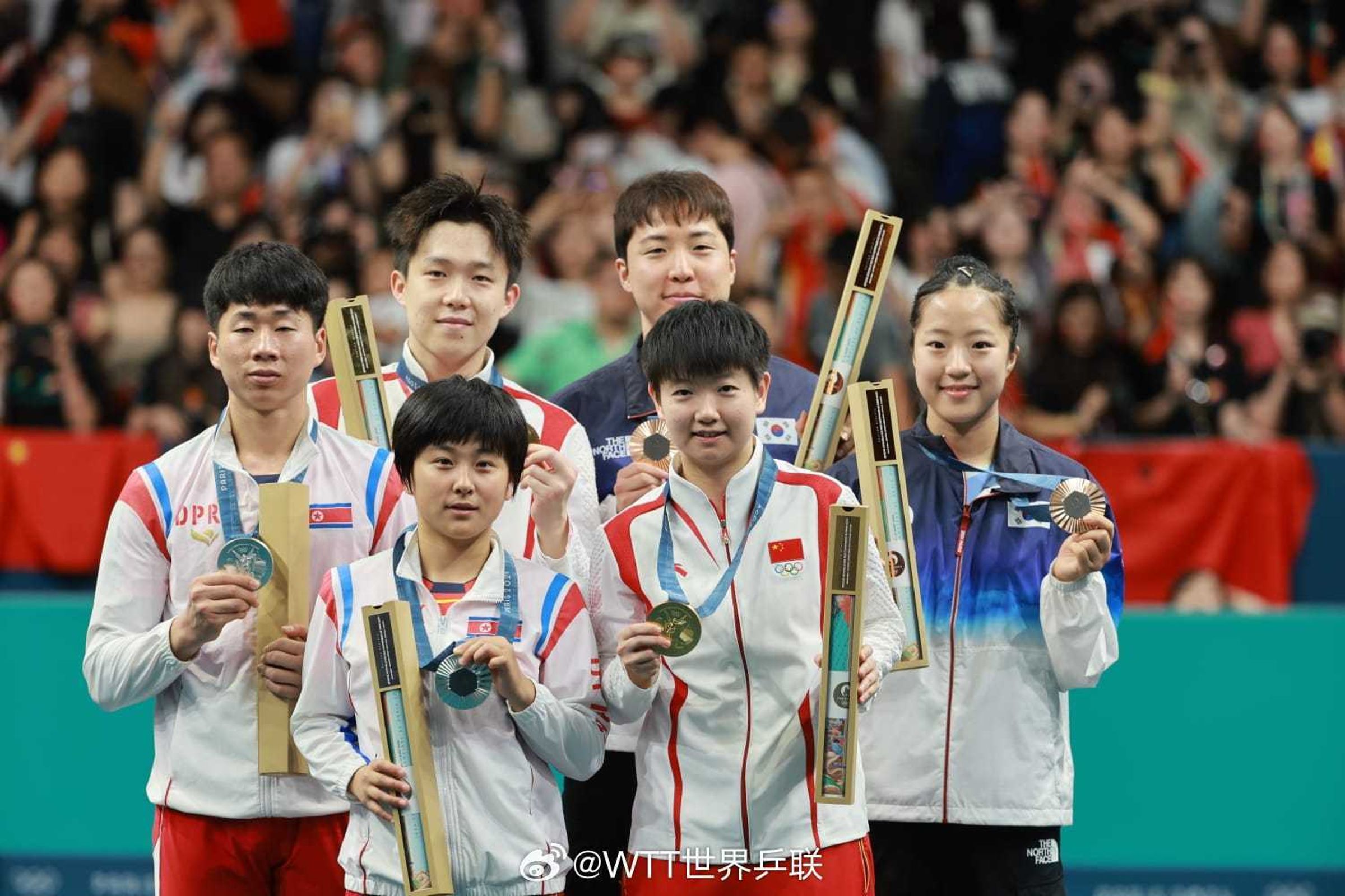 南韓、北韓、中國選手在奧運桌球混雙頒獎典禮同框，成為歷史性畫面。（翻攝WTT世界乒聯微博）
