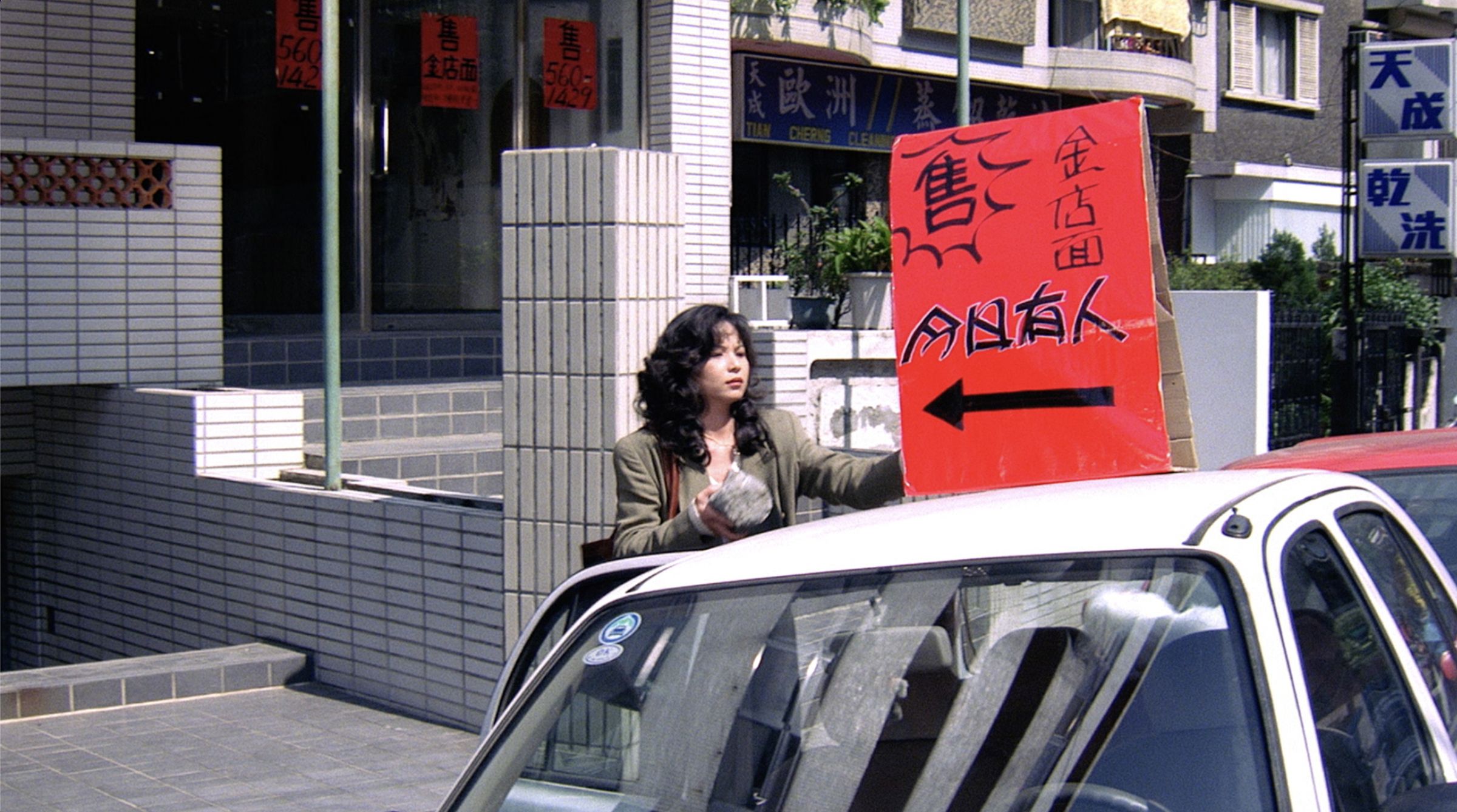 片中楊貴媚飾演房仲,在馬路邊綁廣告牌的畫面深入人心。(國家電影及視聽文化中心提供)