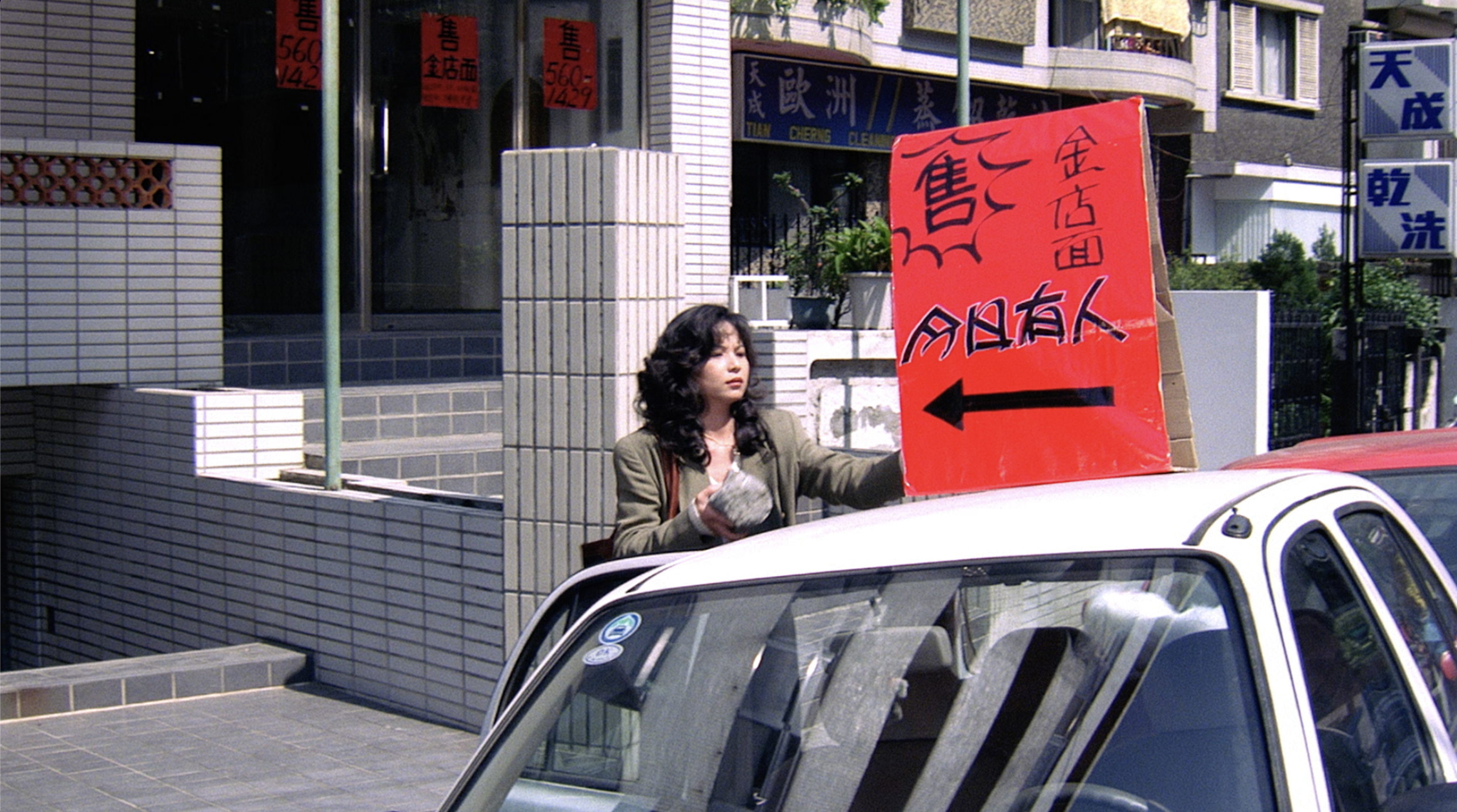 片中楊貴媚飾演房仲,在馬路邊綁廣告牌的畫面深入人心。(國家電影及視聽文化中心提供)