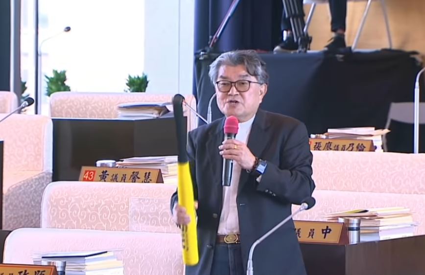台中市議員李中手持「樂樂棒球」的球棒質詢。（翻攝李中愛台中臉書）