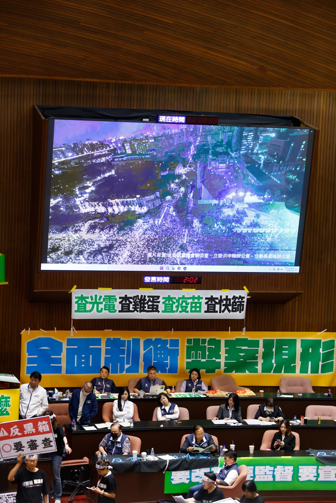 議場螢幕放出場外人潮,對比場內藍委的無視。