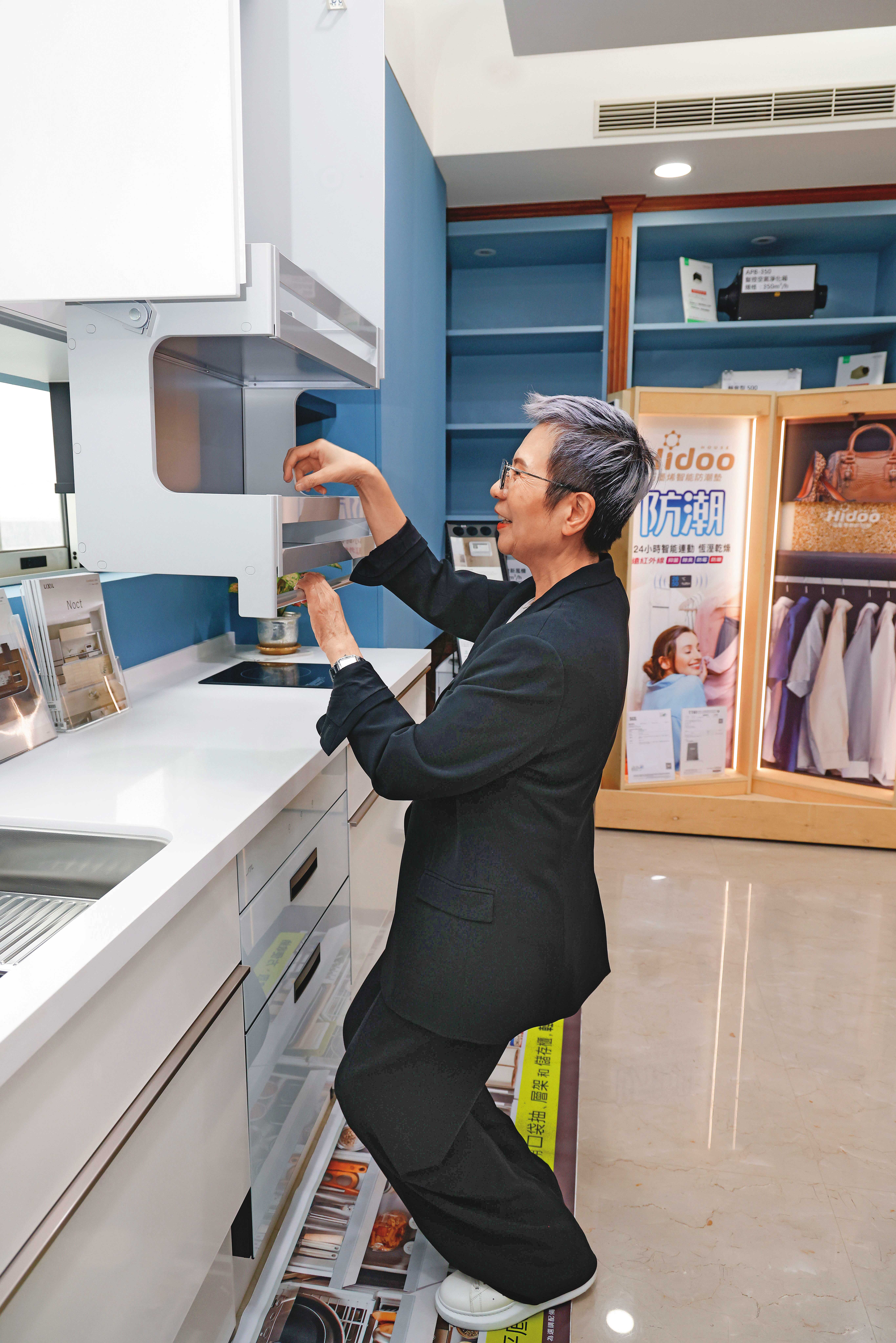 曾婷婷代理日本LIXIL樂齡廚具，她示範即使坐在輪椅上，也可輕易下拉櫃子。