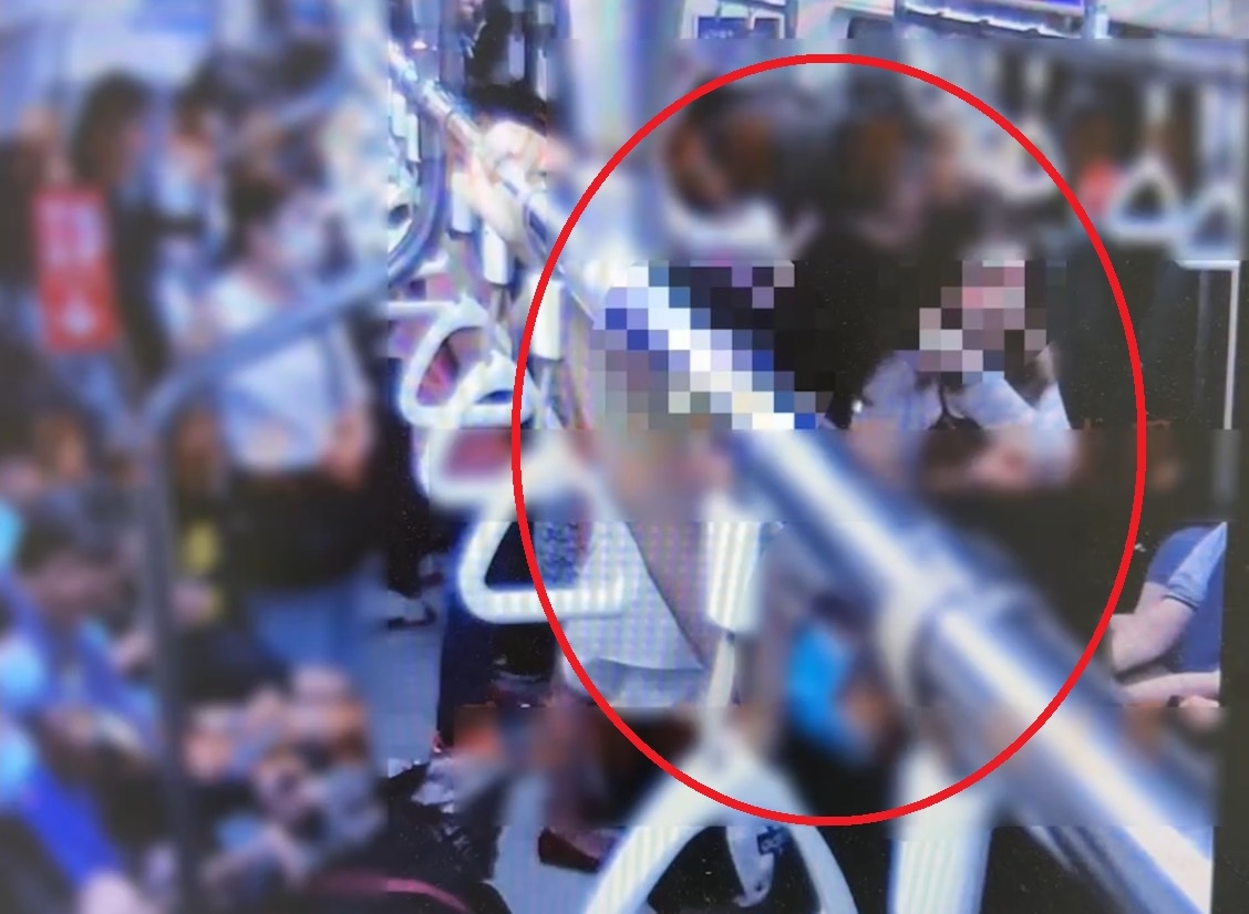 洪姓婦人無故攻擊捷運上女乘客（紅圈右），警方將通知她到案說明。（翻攝畫面）