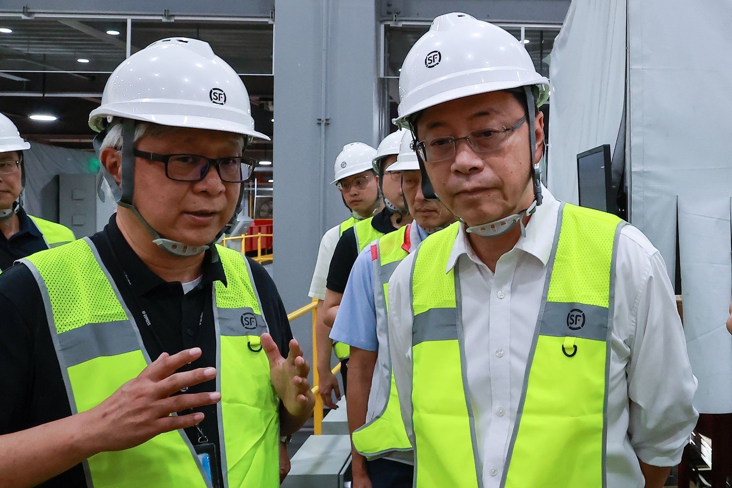 台灣順豐總經理潘逸俊向桃園市長張善政說明全自動化分揀設備運作模式，大幅提升貨件轉運效率。（台灣順豐提供）