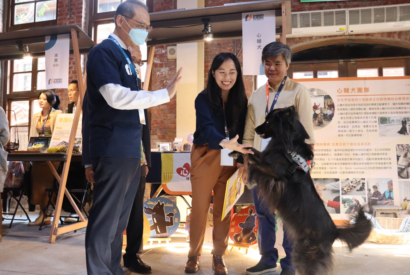 慈濟基金會顏博文（左1）執行長與各團隊互動熱切，「心輔犬」訓練有素，現場穩定性高。（慈濟基金會提供）