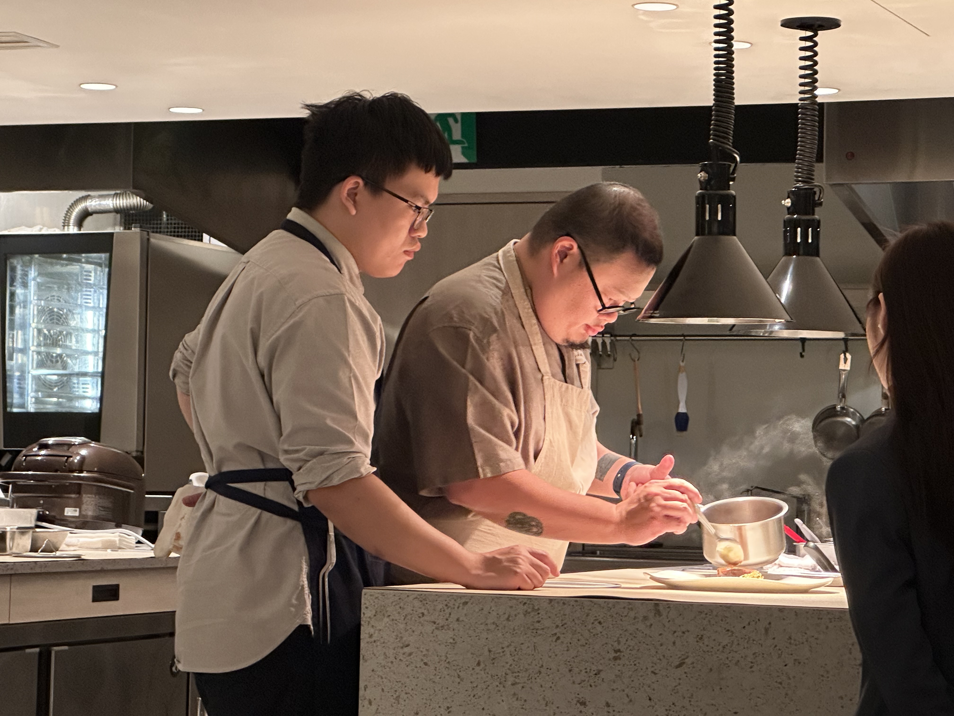 一邊用餐，可以欣賞Nobu Lee（左二）在開放式廚房專注做菜的神情。