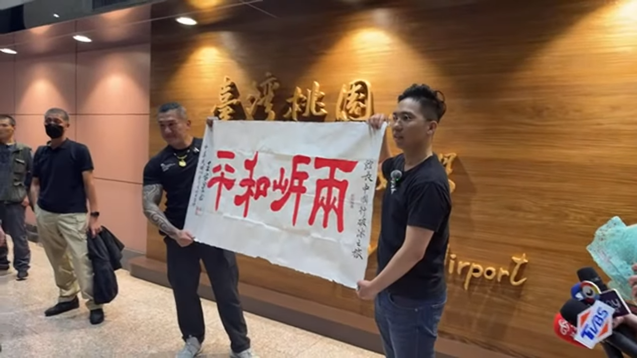 歷史哥來接機，特別送館長「兩岸和平」的布條。（翻攝自館長惡名昭彰直播）