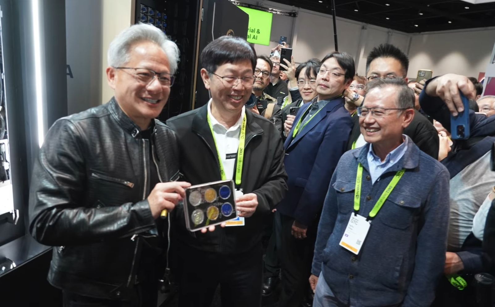 黃仁勳參觀鴻海GTC展位，在GB300 NVL72伺服器機櫃上簽名，劉揚偉隨後從一台機櫃中抽取一盒「鴻海巧克力」致贈，兩人合照留念。（翻攝自鴻海科技集團臉書）