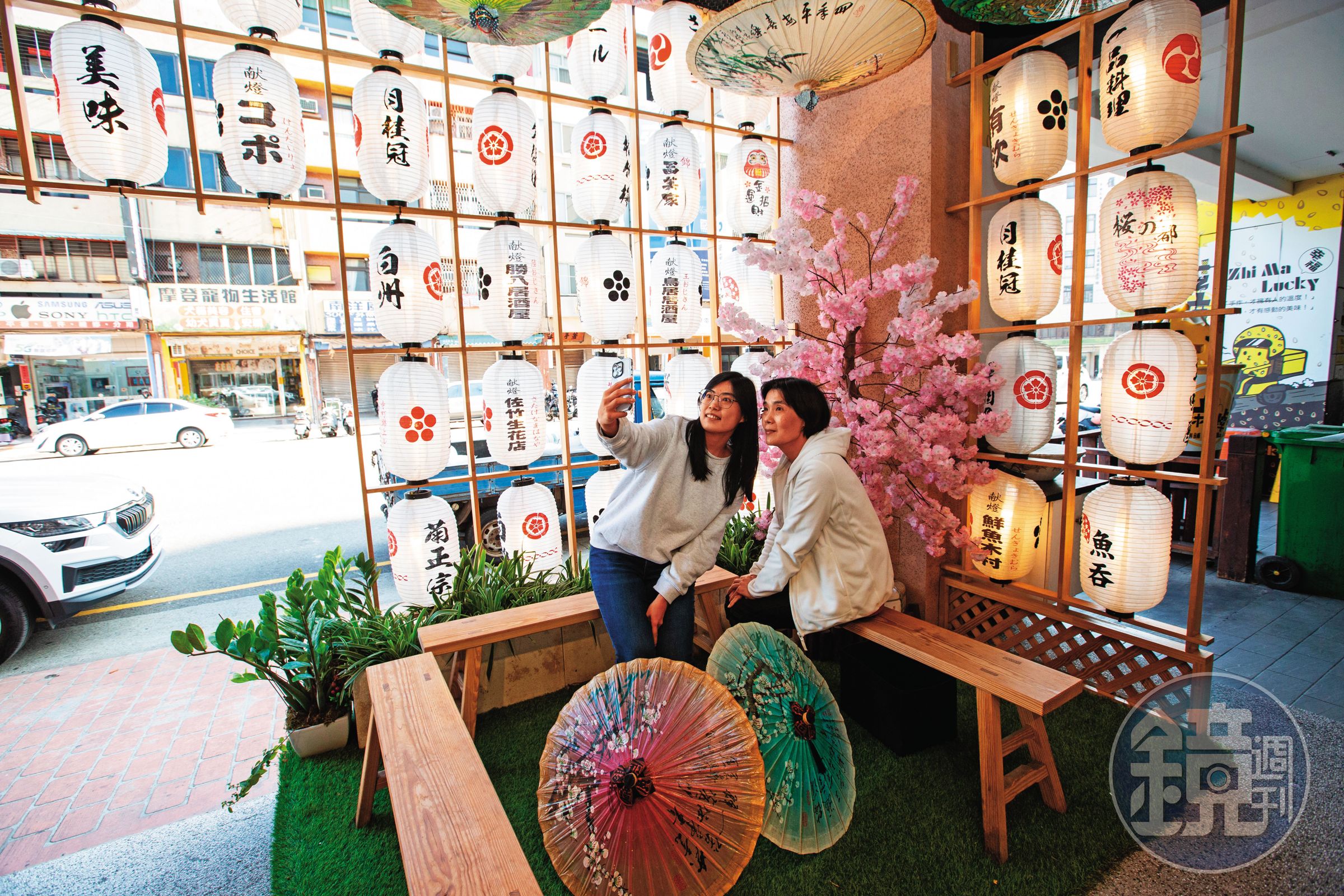 魚吞壽司店外候客區設計有美美的日式燈籠、美濃紙傘網美牆,吸引顧客拍照打卡。