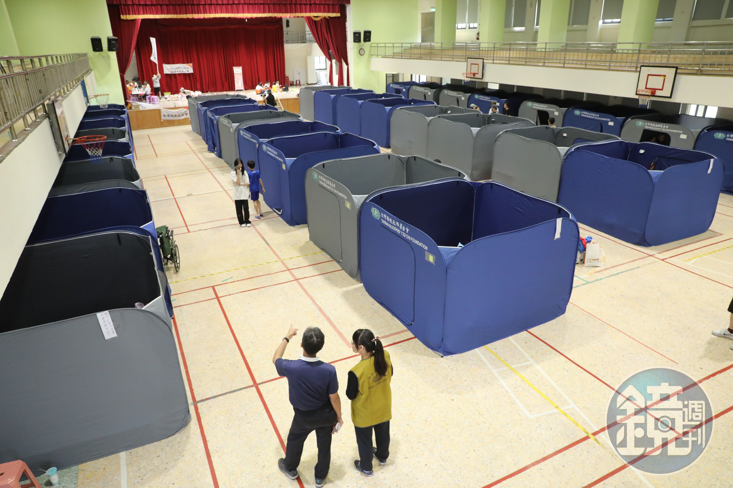 慈濟基金會在國小體育館架設「淨斯福慧環保隔屏」,提供災民隱私空間。
