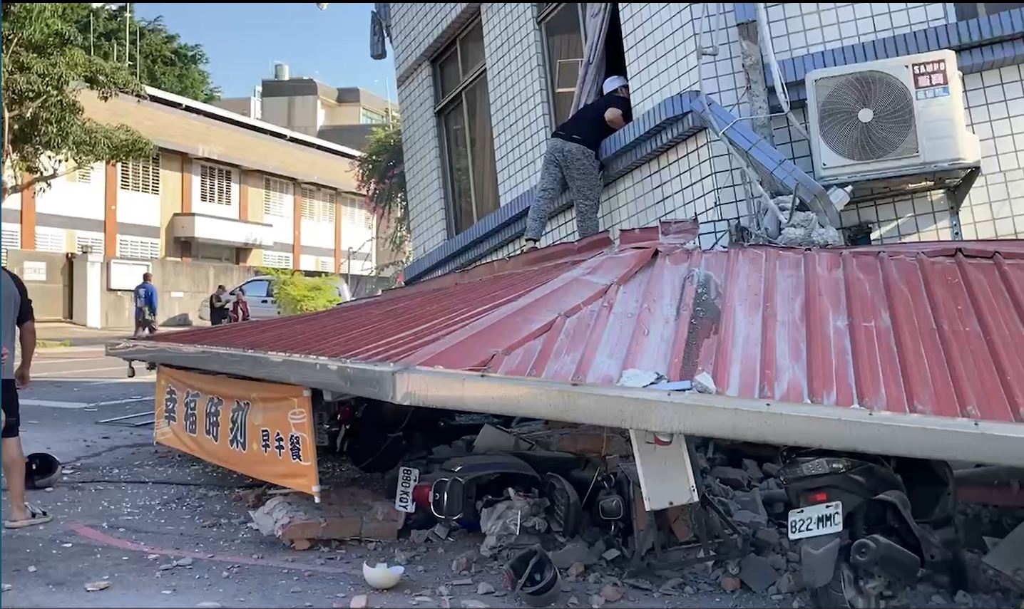 民眾攀上鐵皮救援位於坍塌建物二樓的人。(讀者提供)