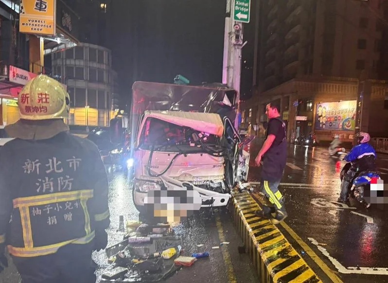 林姓男子駕駛貨車行經新莊中正路，疑似擦拭眼鏡上雨滴，未注意撞上中央分隔島。（翻攝畫面）