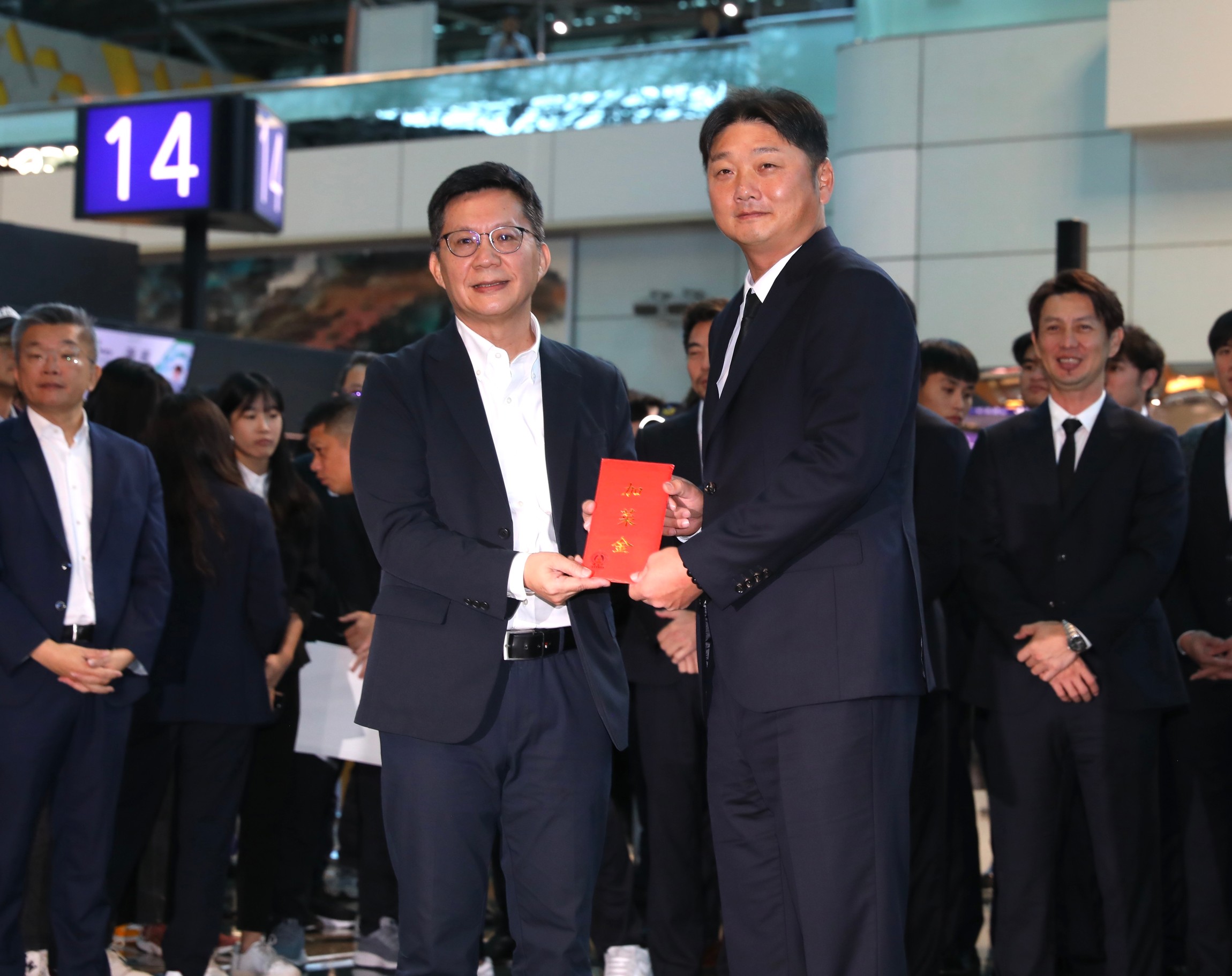 總教練曾豪駒代表收下張廖萬堅致贈的20萬元加菜金。