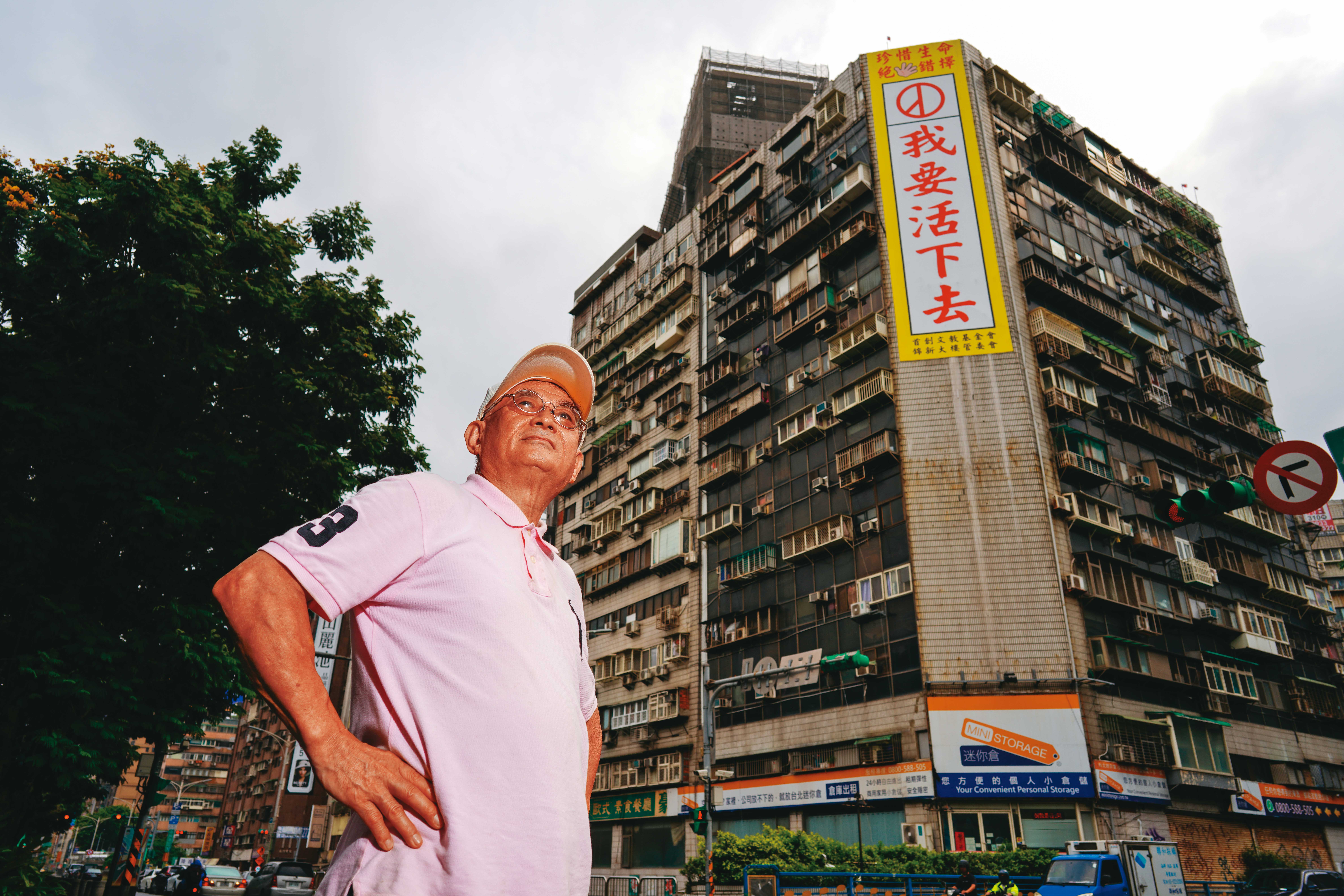 錦新大樓管委會主委周朝陽在大樓牆面掛上「我要活下去」的看板，希望尋死者看到後能轉念。