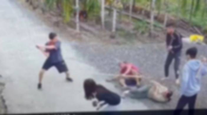 紅衣男子持西瓜刀疑似有攻擊行為,遭多位民眾以竹竿、鋤頭制服。(翻攝爆料公社)