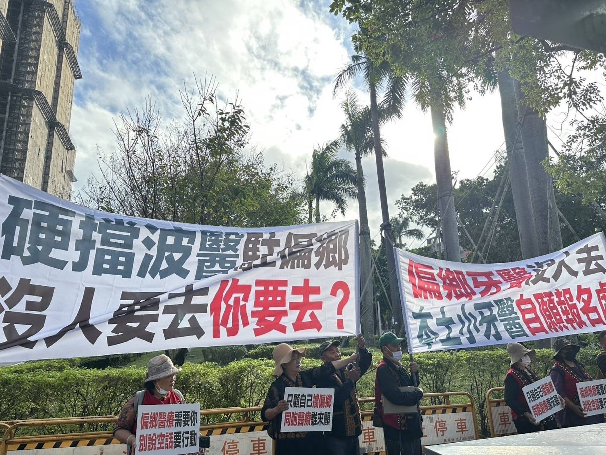 偏鄉民眾在遊行現場設攤招募本土牙醫,高喊:「自己不來別擋波醫!」(范武吉提供)