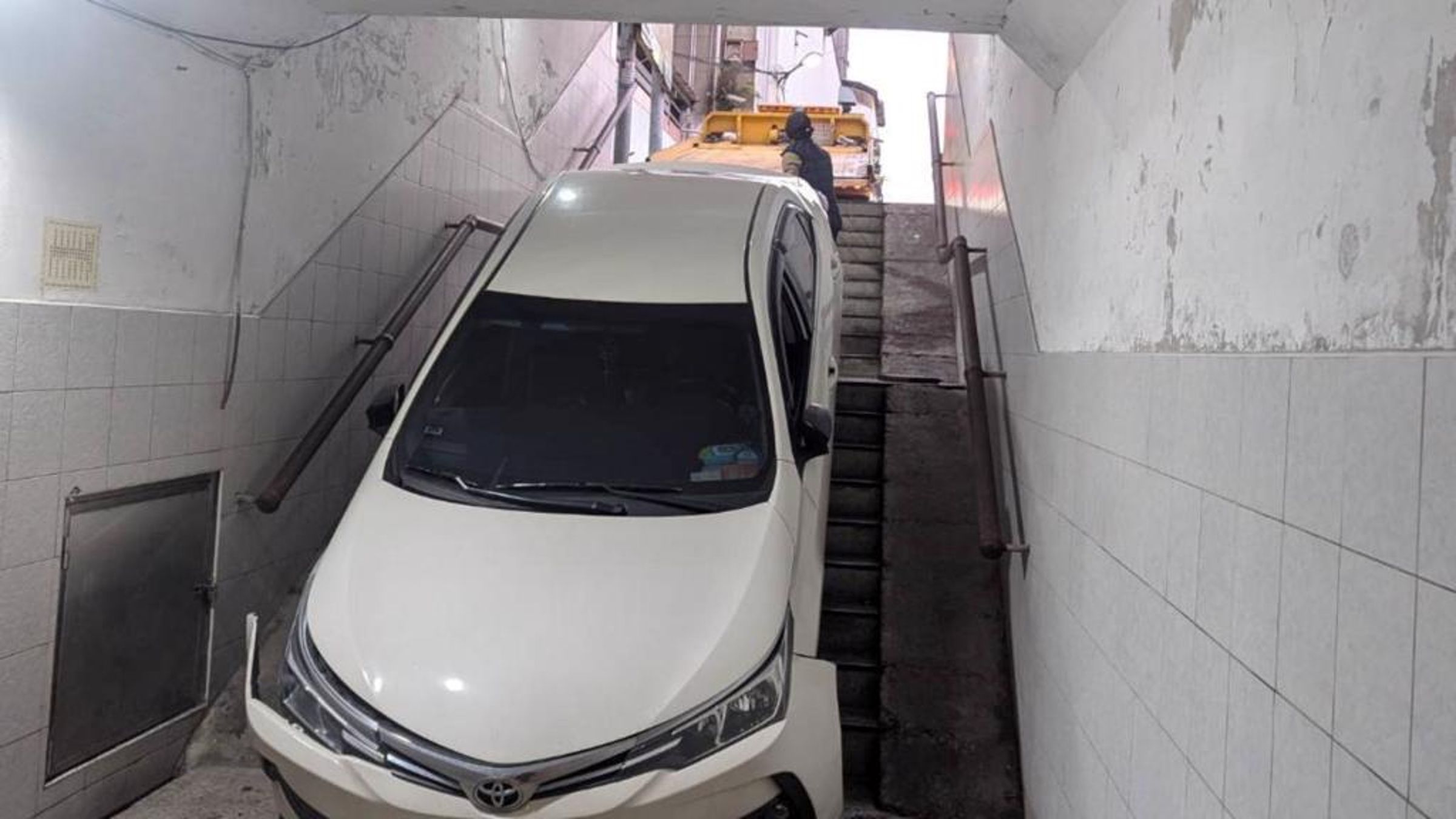 新北市一名王姓女子誤將車子開進人行地下道,又因拖吊廠商失誤,導致車輛下滑更多。(翻攝畫面)