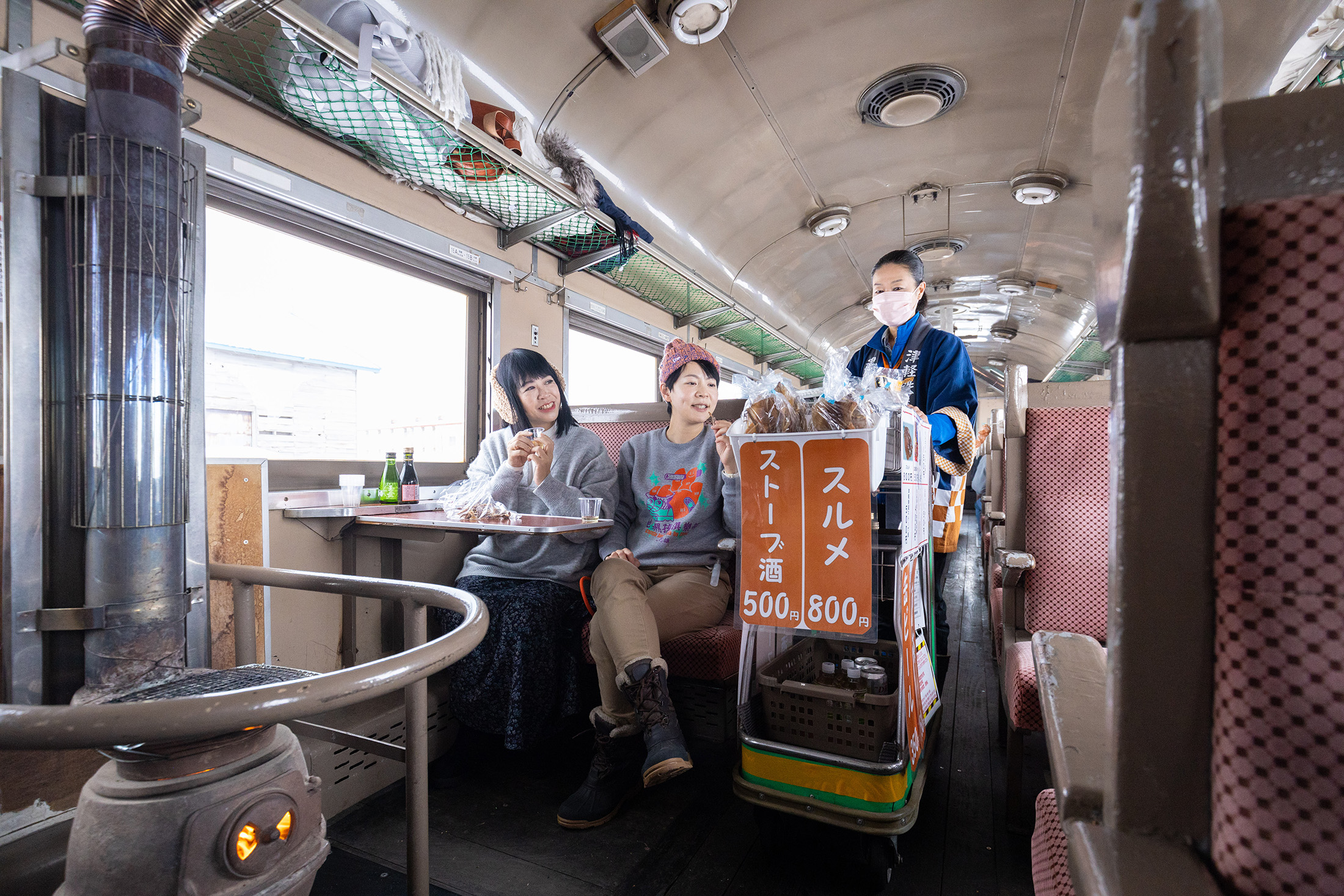 搭乘津輕鐵道暖爐列車的內行人都知道，列車上最靠近炭爐的座位，永遠都是最熱門的區域，可以好整以暇等待小餐車推近，購買想要的零嘴。