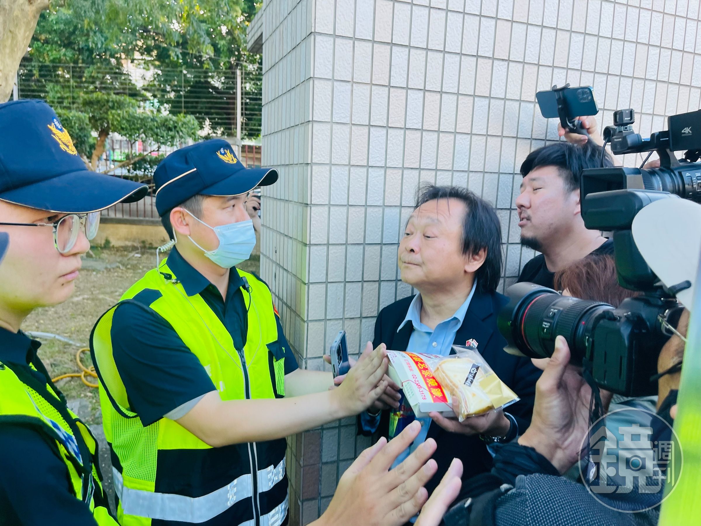 王世堅手持雞鴨便當、起酥蛋糕。