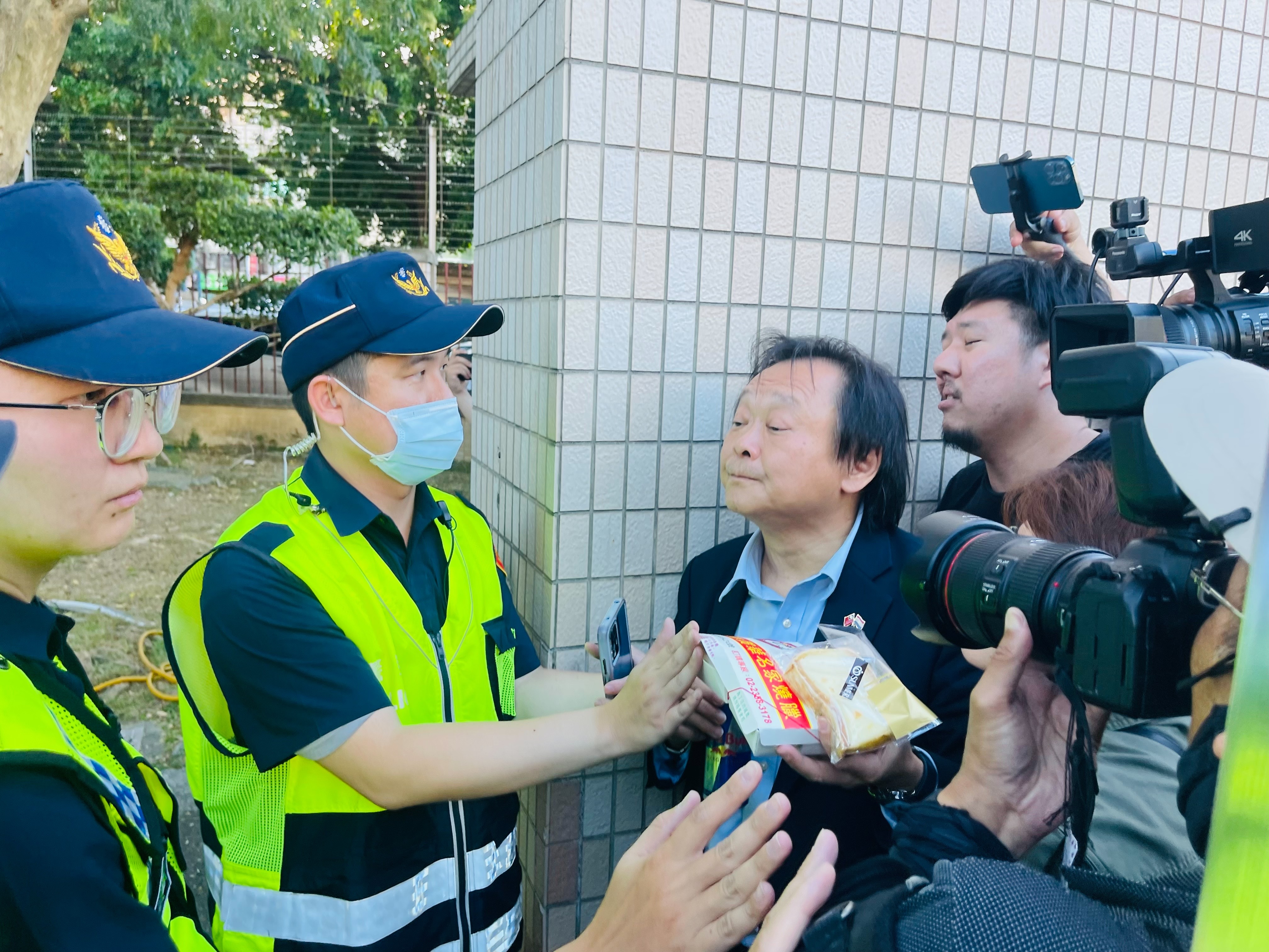 王世堅手持雞鴨便當、起酥蛋糕。