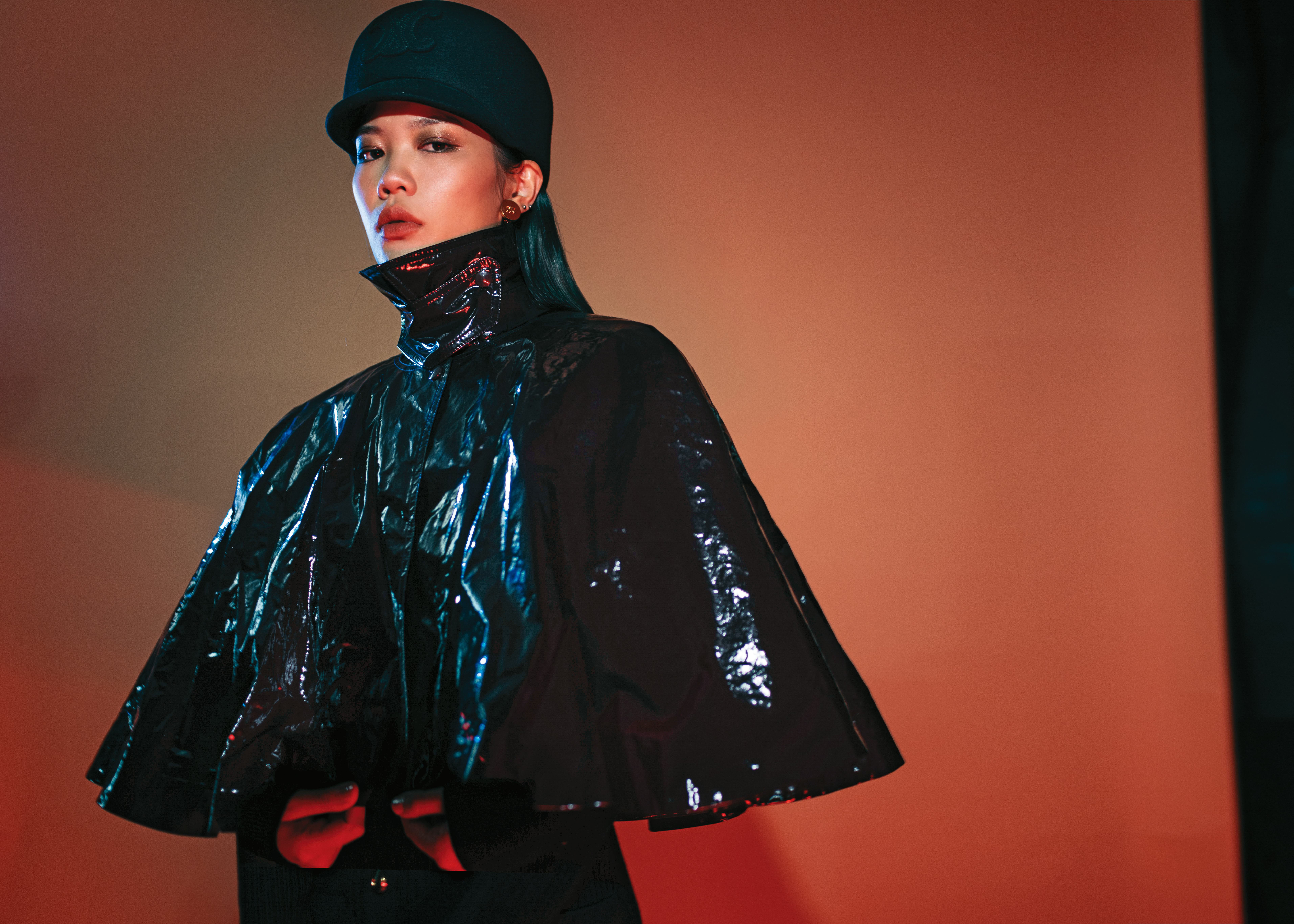 暗褐色亮漆棉質斗篷NT$98,000 by Chloé／海軍藍低衝擊多針羊毛針織衫NT$72,300 by Chloé／TRIOMPHE羊毛氈絨鴨舌帽NT$32,500 by CELINE BY HEDI SLIMANE／金色飾面CELINE PETALE耳環NT$26,000 by CELINE BY HEDI SLIMANE