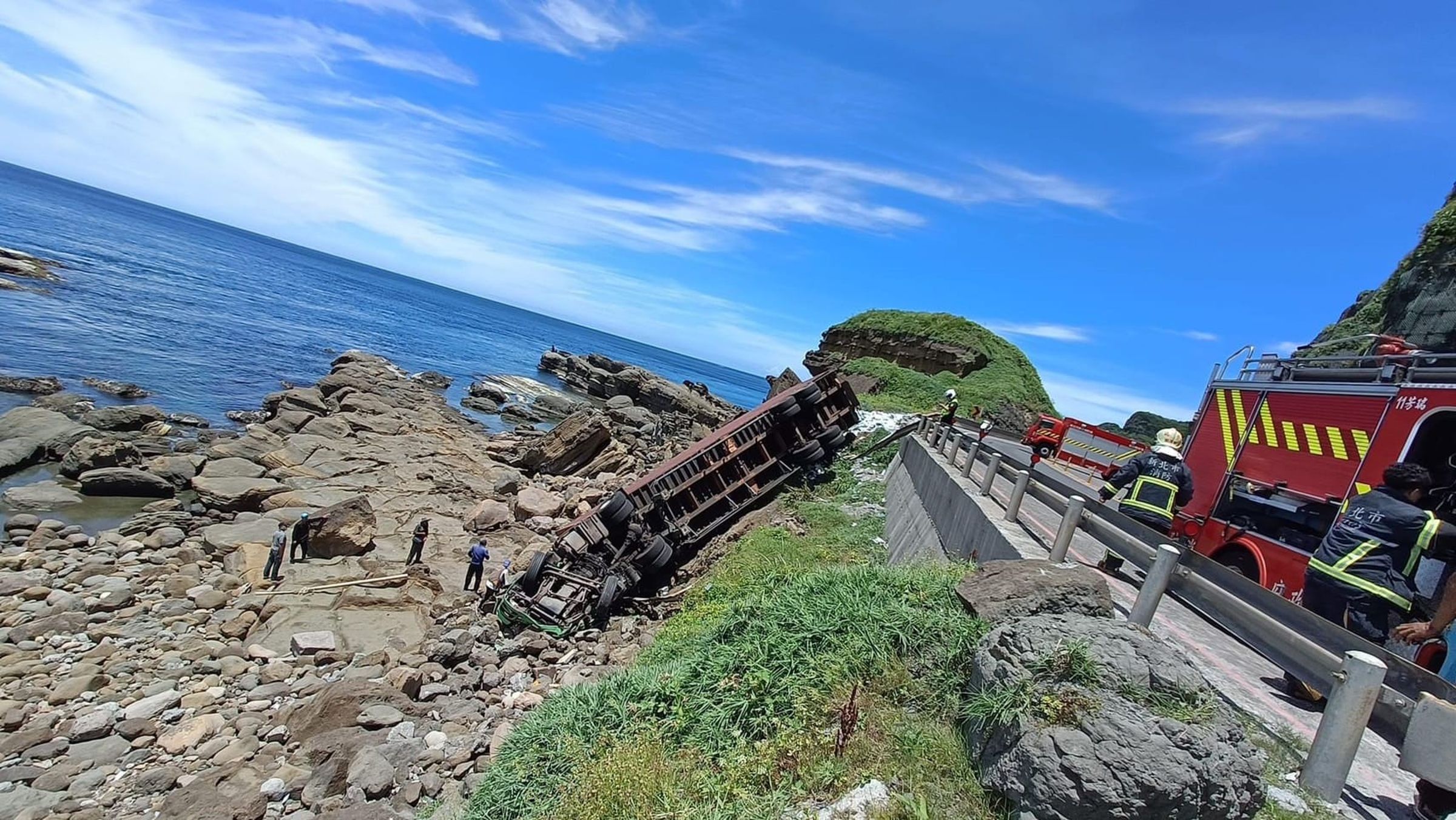 貨櫃車今午不明原因衝破台2線路邊護欄，墜落在邊坡上。（翻攝自記者爆料網）