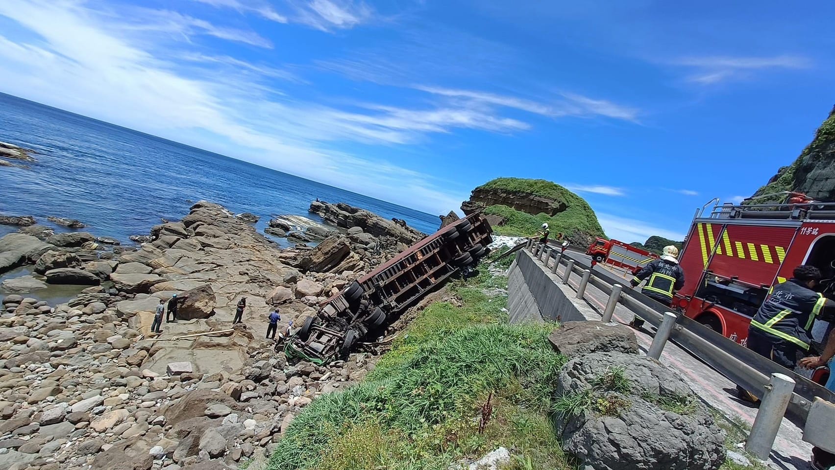貨櫃車今午不明原因衝破台2線路邊護欄，墜落在邊坡上。（翻攝自記者爆料網）