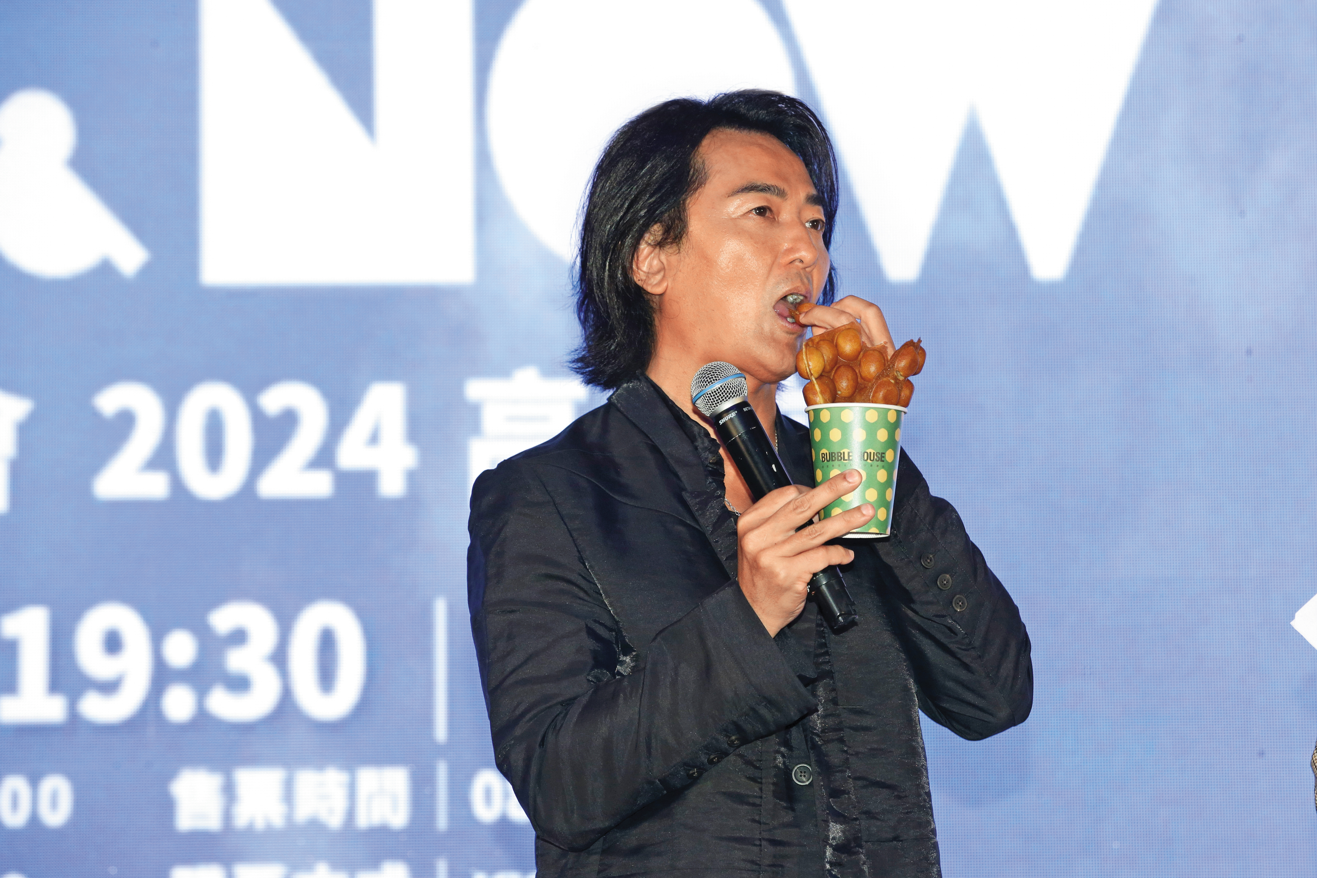 鄭伊健在台上大啖雞蛋仔，模樣太接地氣，不說小編以為是在香港街頭。