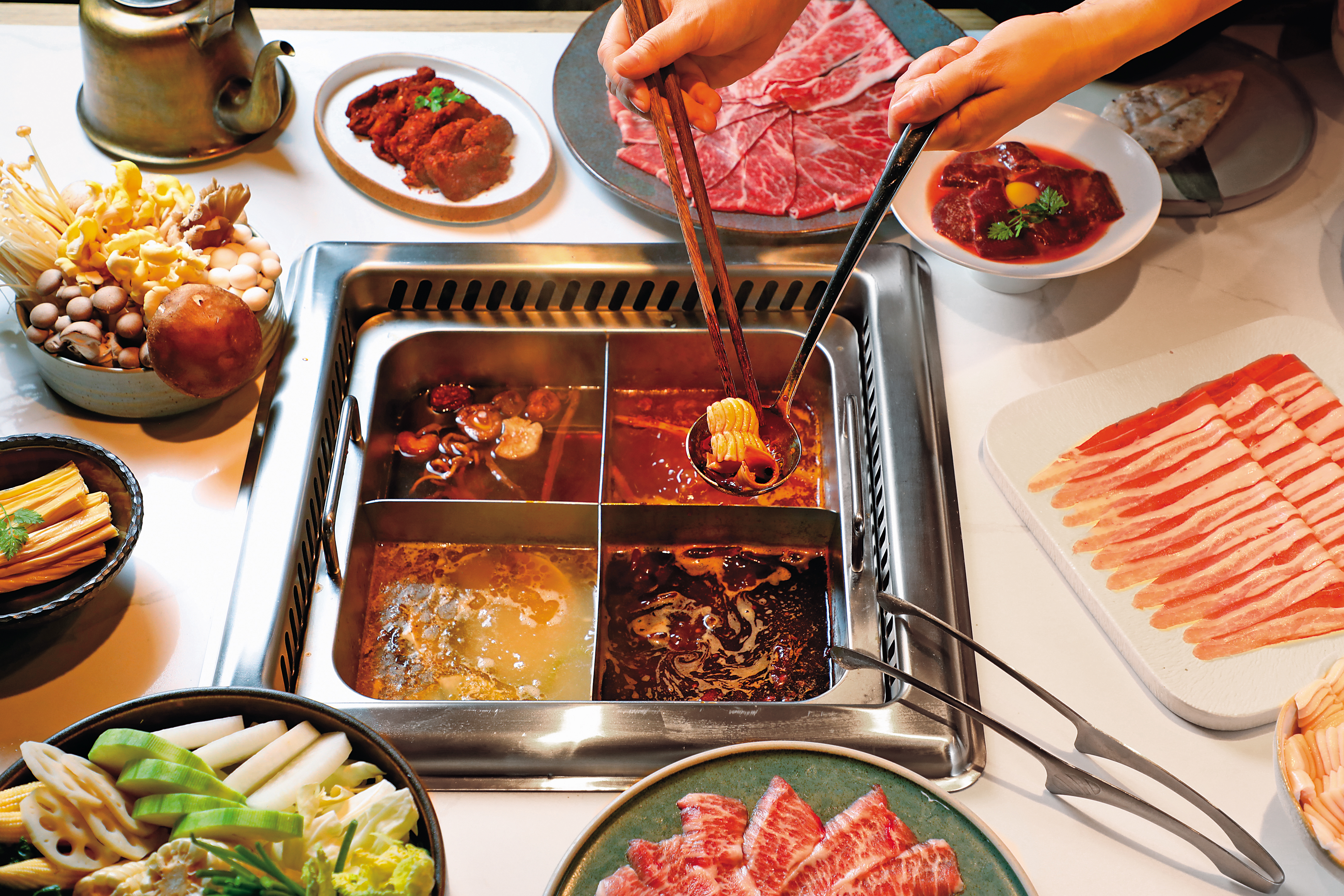 點四宮格可把「重慶牛油鍋」(右下,320元/份)「酸菜魚鍋」(左下,220元/份)「番茄鍋」(右上,240元/份)和「菌菇鍋」(左上,180元/份)一網打盡。
