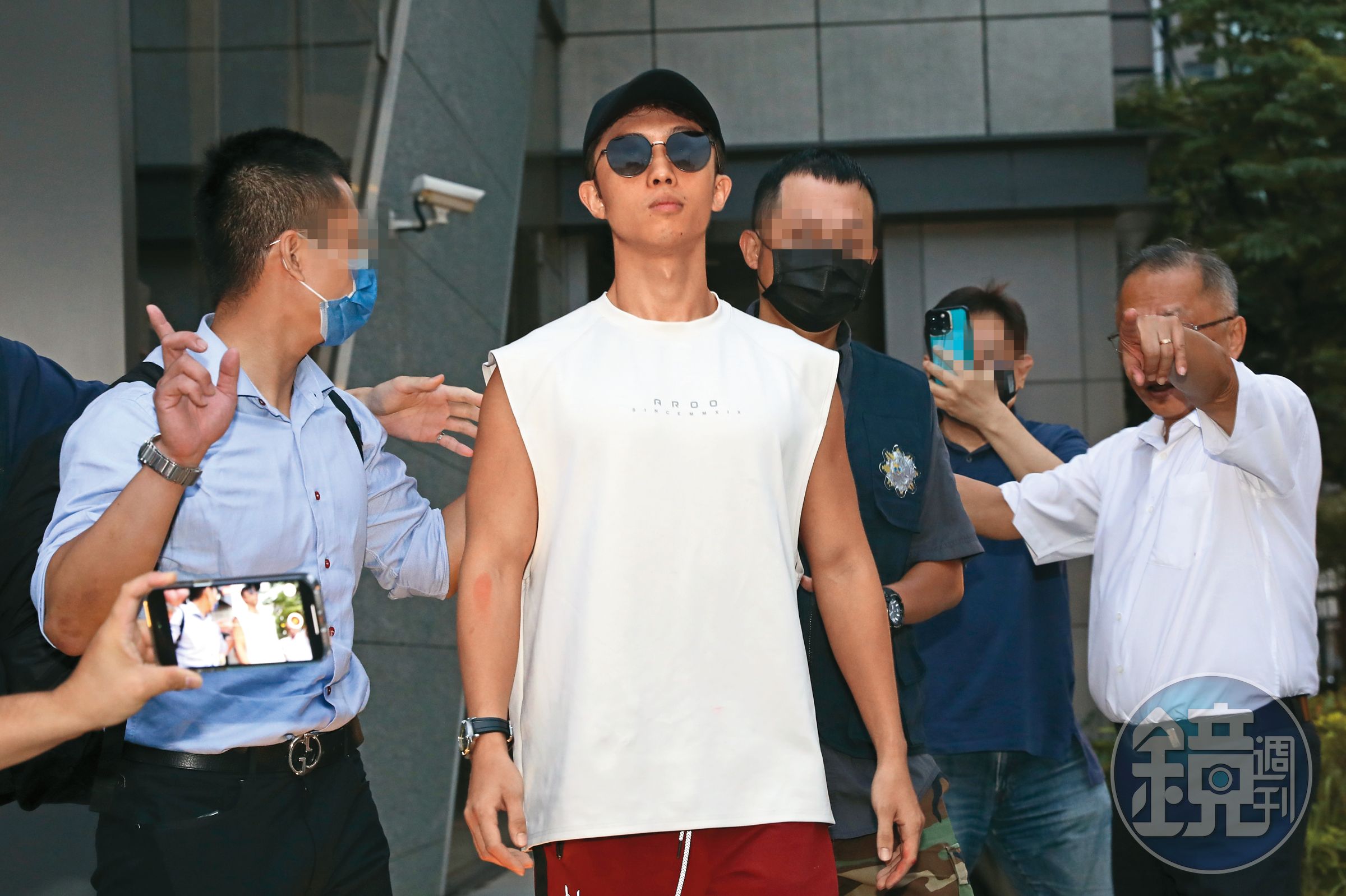 孫安佐(左二)從北市刑大帶出移送北檢,他因攜帶瓦斯火槍在北市信義區的夜店外進行實測,引起群眾圍觀議論。警方隨後介入調查,發動搜索行動,在孫鵬家中查扣疑似火藥的粉末、刀械以及瓦斯火槍等物品。
