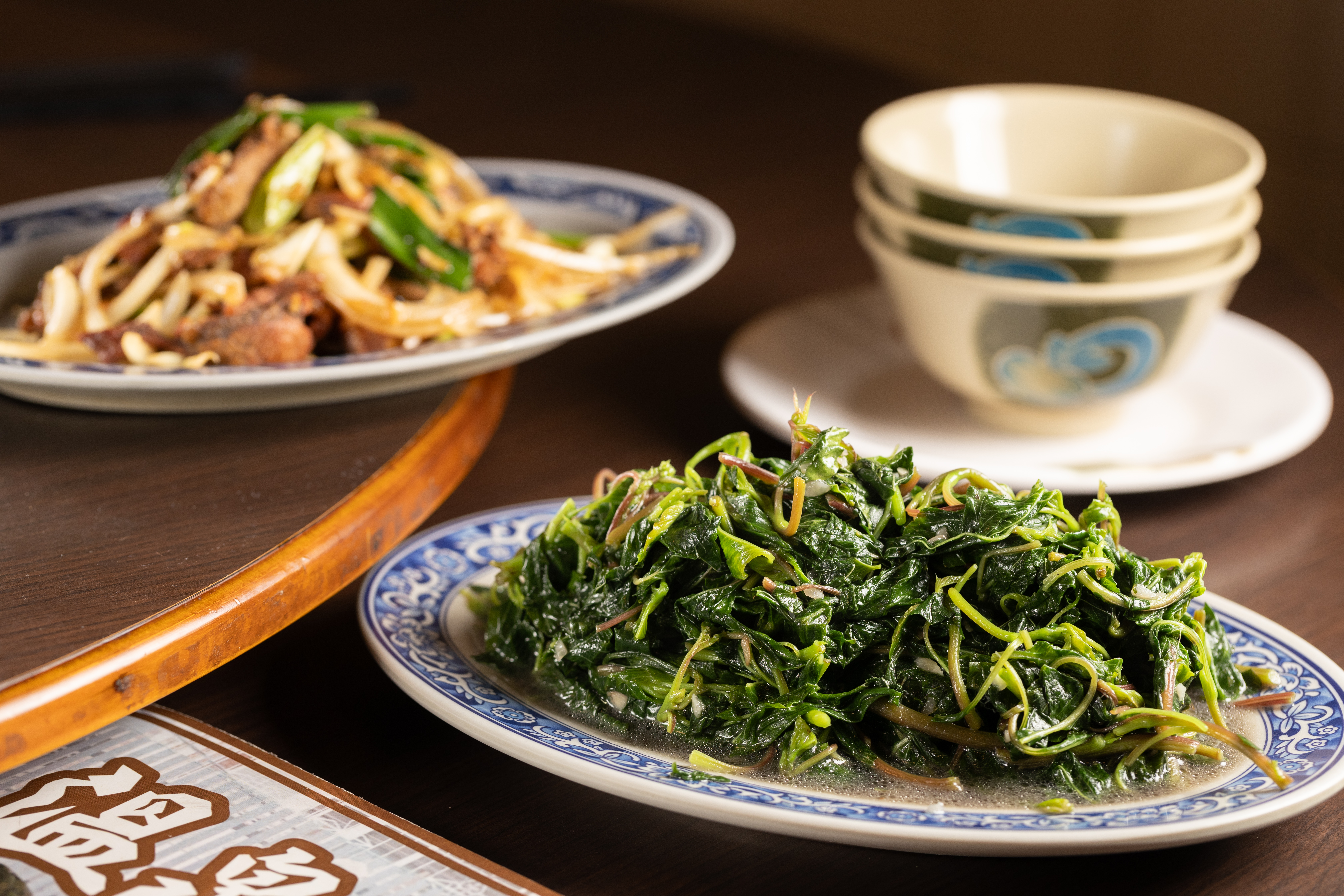 並非每天都吃得到的手摘野菜「山莧菜」（前，120元／份），雨季時會特別嫩；「蔥爆鴕鳥肉」（後，250元／份）使用屏東在地養殖的鴕鳥肉。