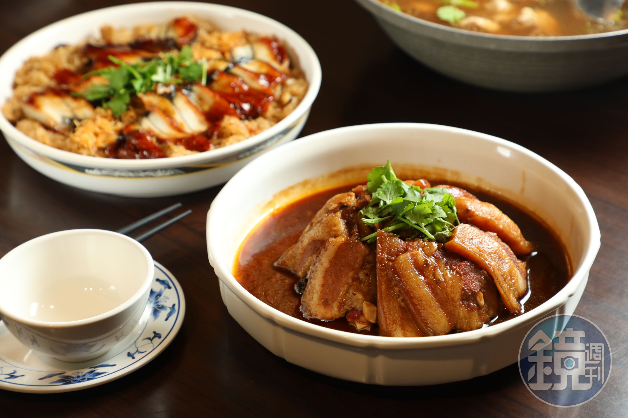 大烹小饌的「梅香古早扣方」(前,年菜980元/份)將三層肉炸出虎皮再去蒸,美味秘訣是分兩次蒸煮入味;搭配以黑麻油拌炒油飯的「黑麻油鰻貝御飯」(後,年菜980元/份)。
