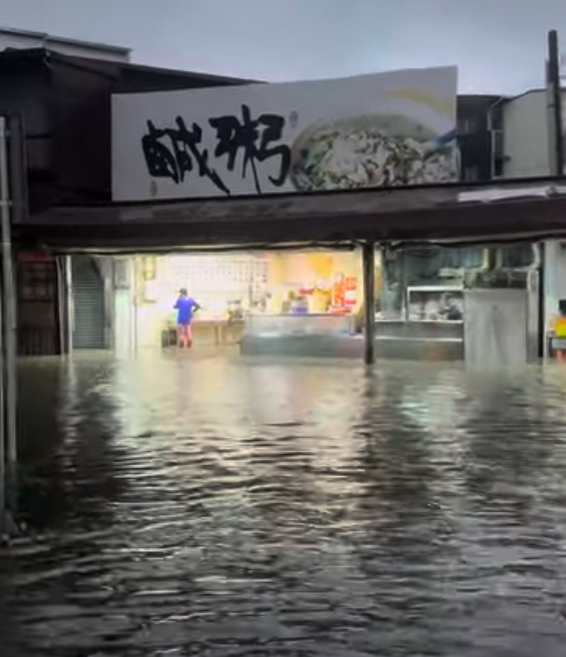 水淹進阿堂鹹粥店內,員工看起來很無奈。(翻攝記者爆料網)