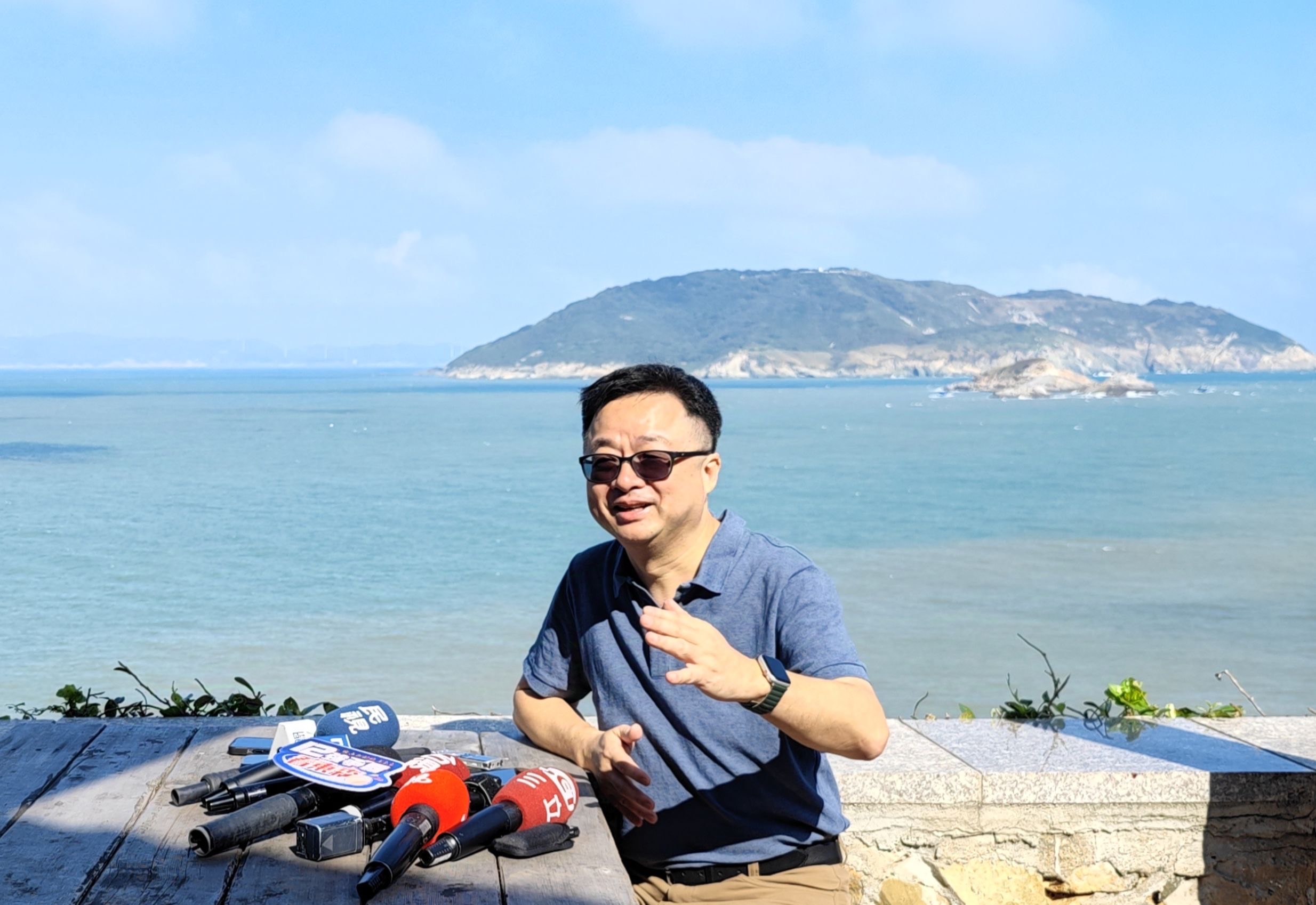 海基會秘書長羅文嘉在大坵島上受訪。後為高登島。(海基會提供)