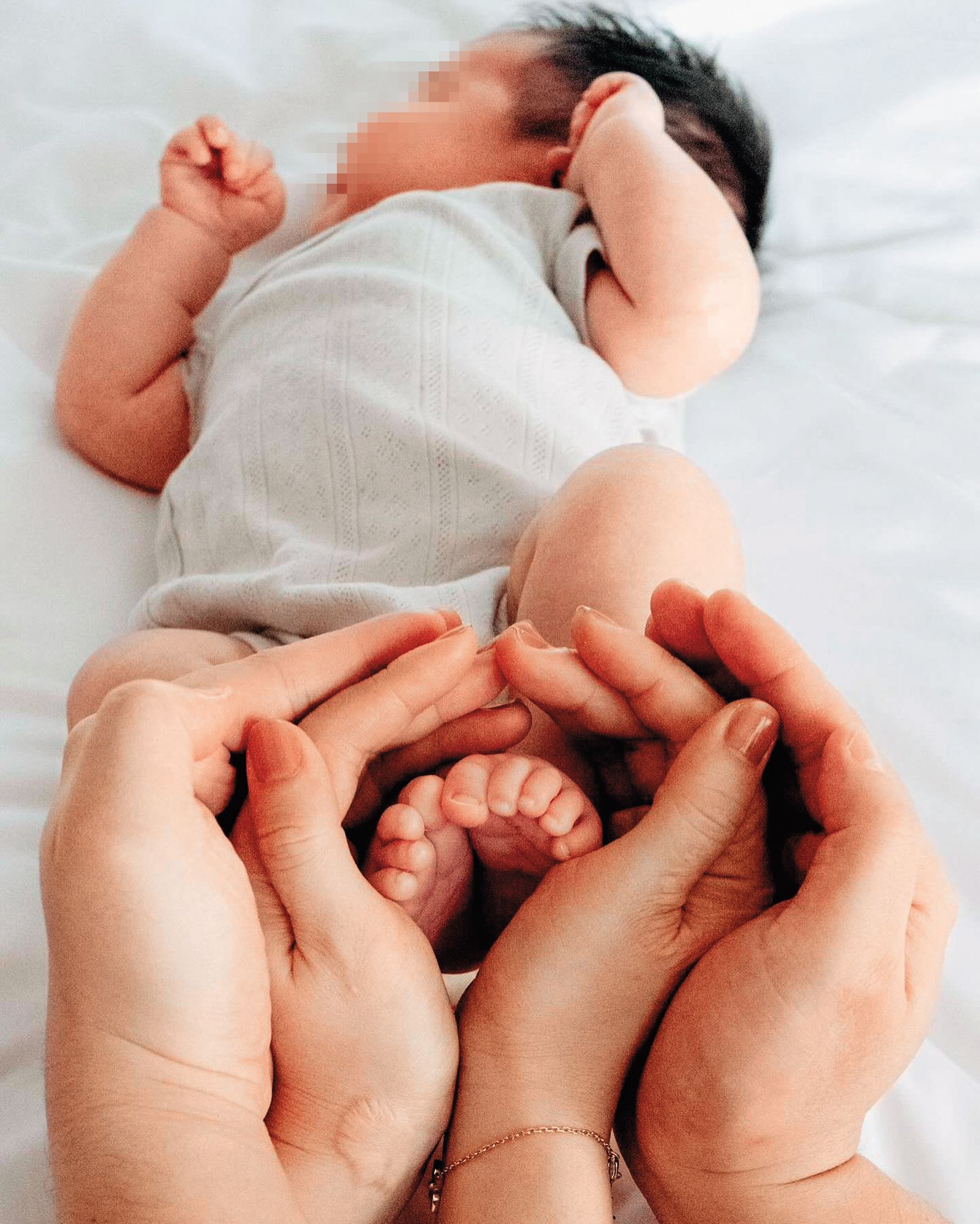 兒子出生後，Selina曬出她與另一半用手圈住小腰果腳腳的照片。（翻攝自任家萱臉書）