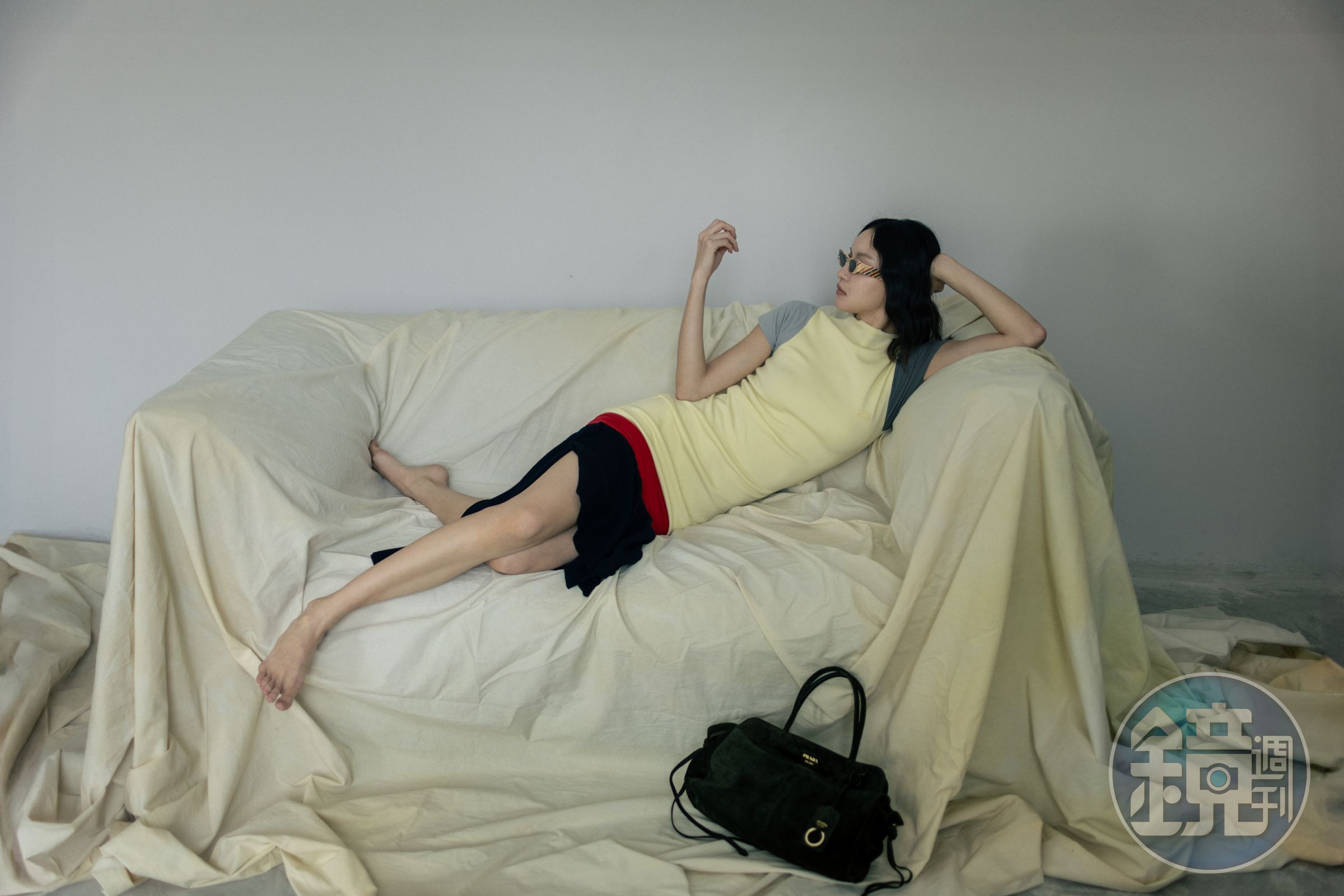 羊毛和嫘縈混紡洋裝 NT$74,000 by LOEWE；彩色條紋墨鏡 NT$12,800 by LOEWE；Prada Carry麂皮肩背包 價格店洽 by PRADA。