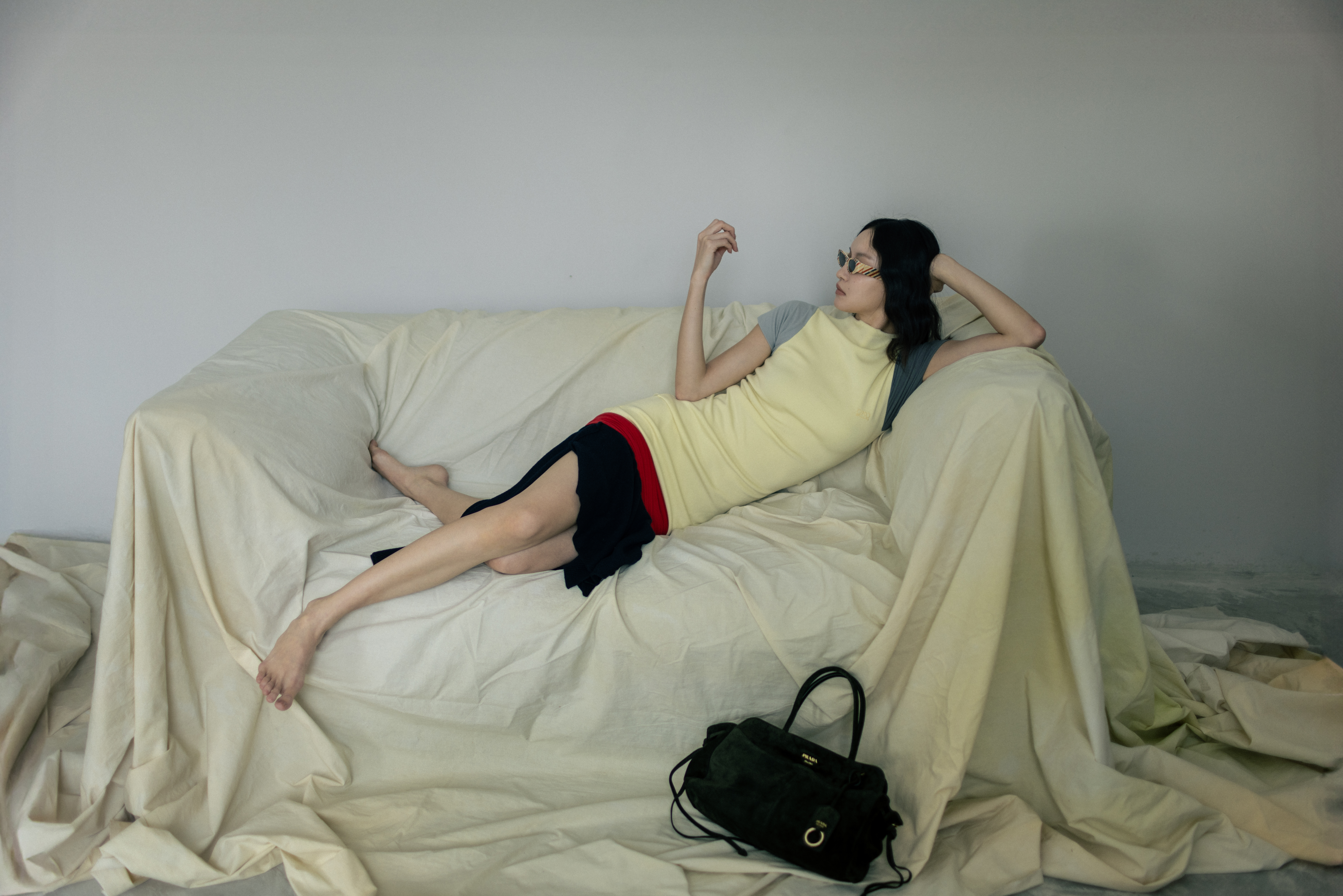 羊毛和嫘縈混紡洋裝 NT$74,000 by LOEWE;彩色條紋墨鏡 NT$12,800 by LOEWE;Prada Carry麂皮肩背包 價格店洽 by PRADA。