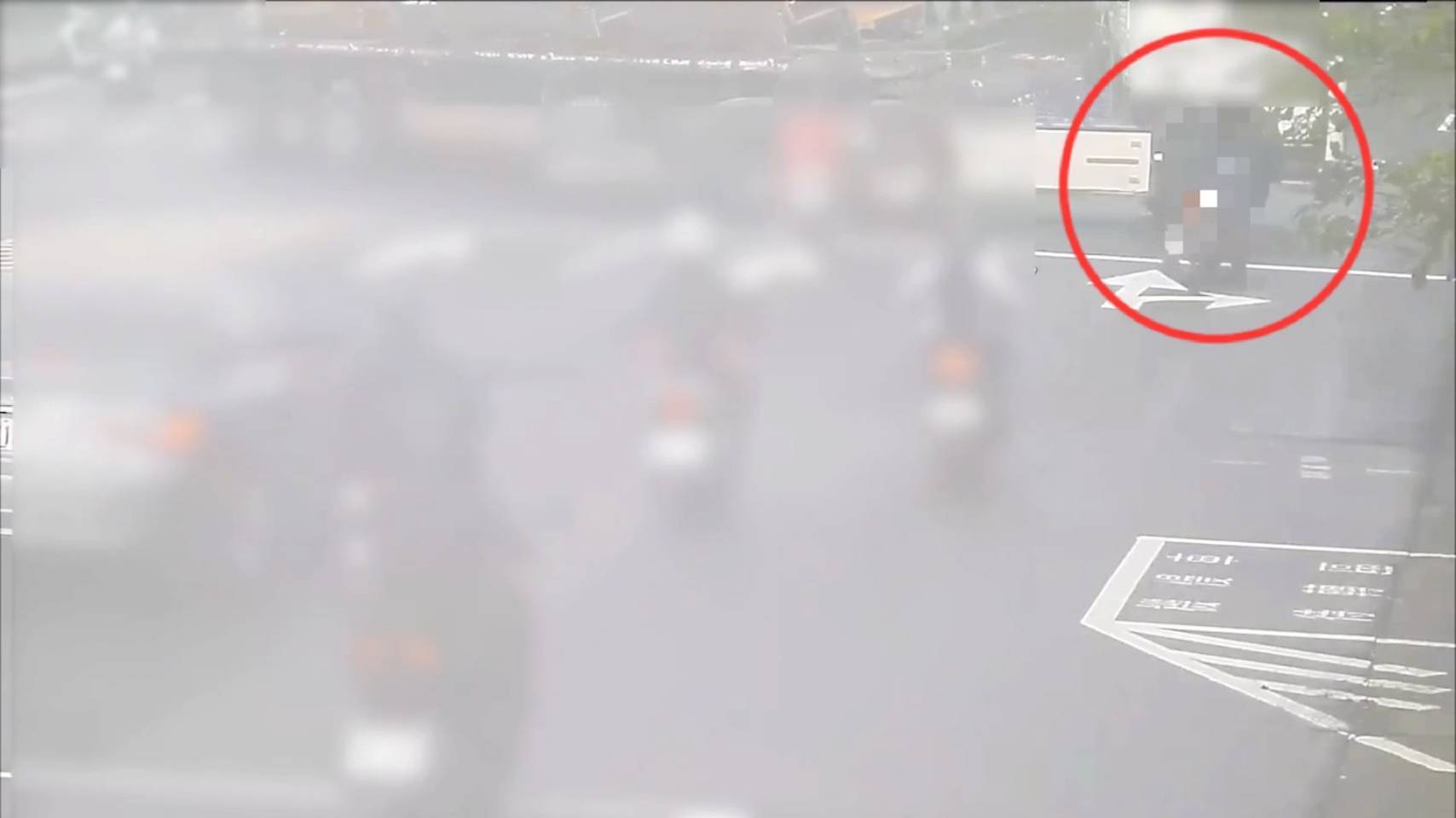 直行的郭姓機車騎士（紅圈）見前方曳引車迴轉，因煞車打滑捲進車底遭輾斃。（翻攝畫面）