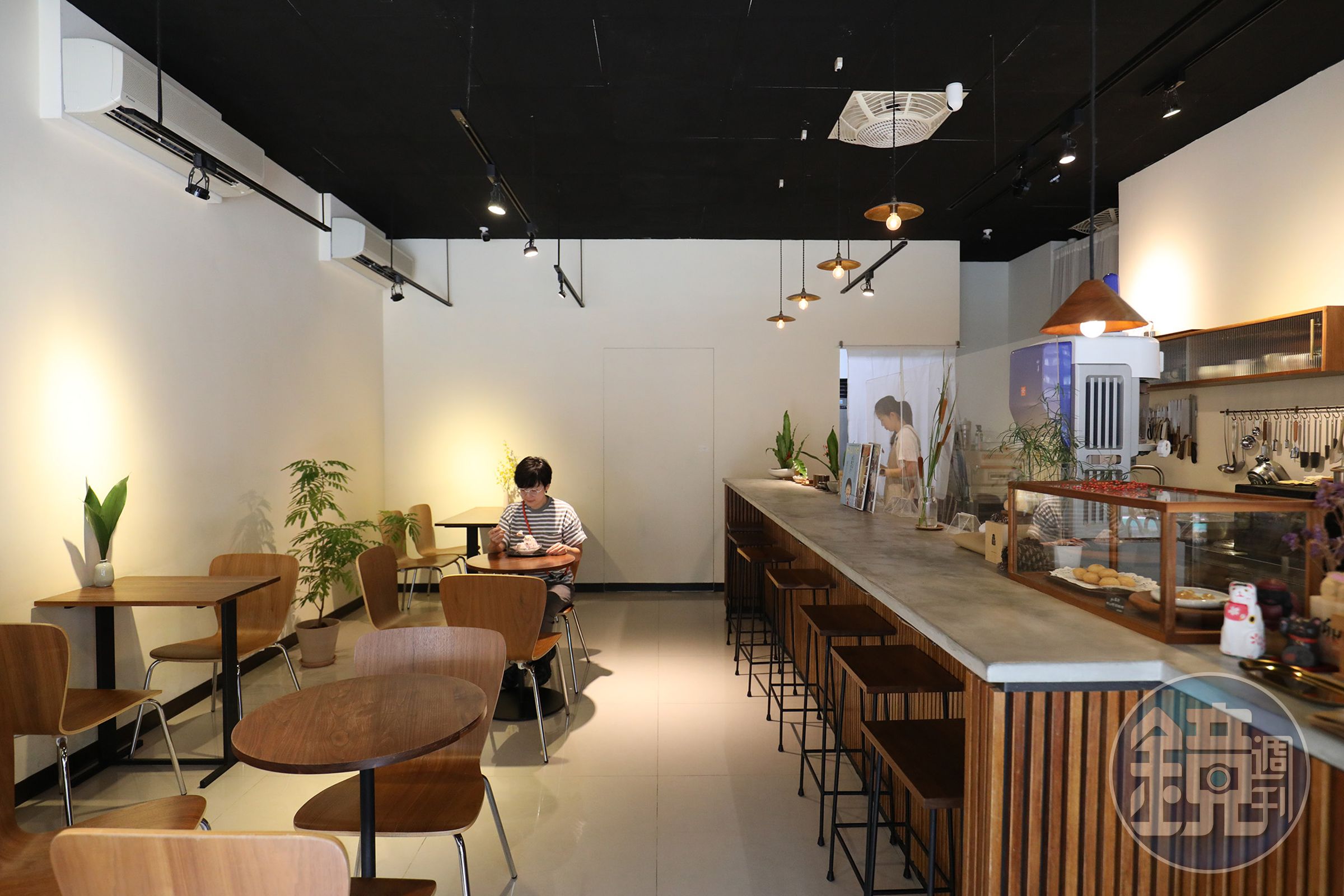 店內以木質家具與留白牆面營造日式氛圍，吧台座位讓客人近距離欣賞刨冰製作過程。