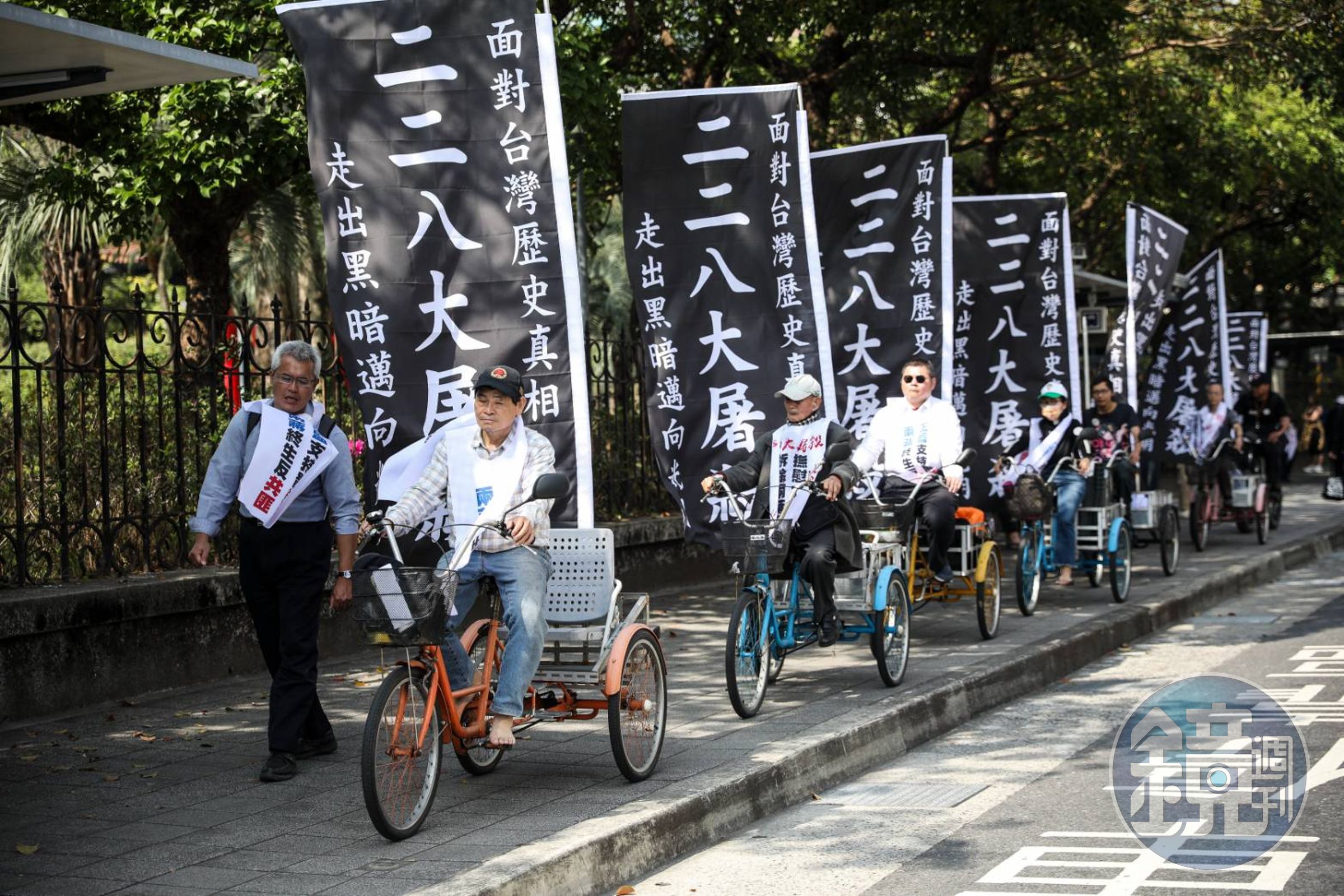 228事件78週年追思會,抗議團體在腳踏車上插著大大的「二二八大屠殺,面對台灣歷史真相,走出黑暗邁向光明」黑底白字布條。
