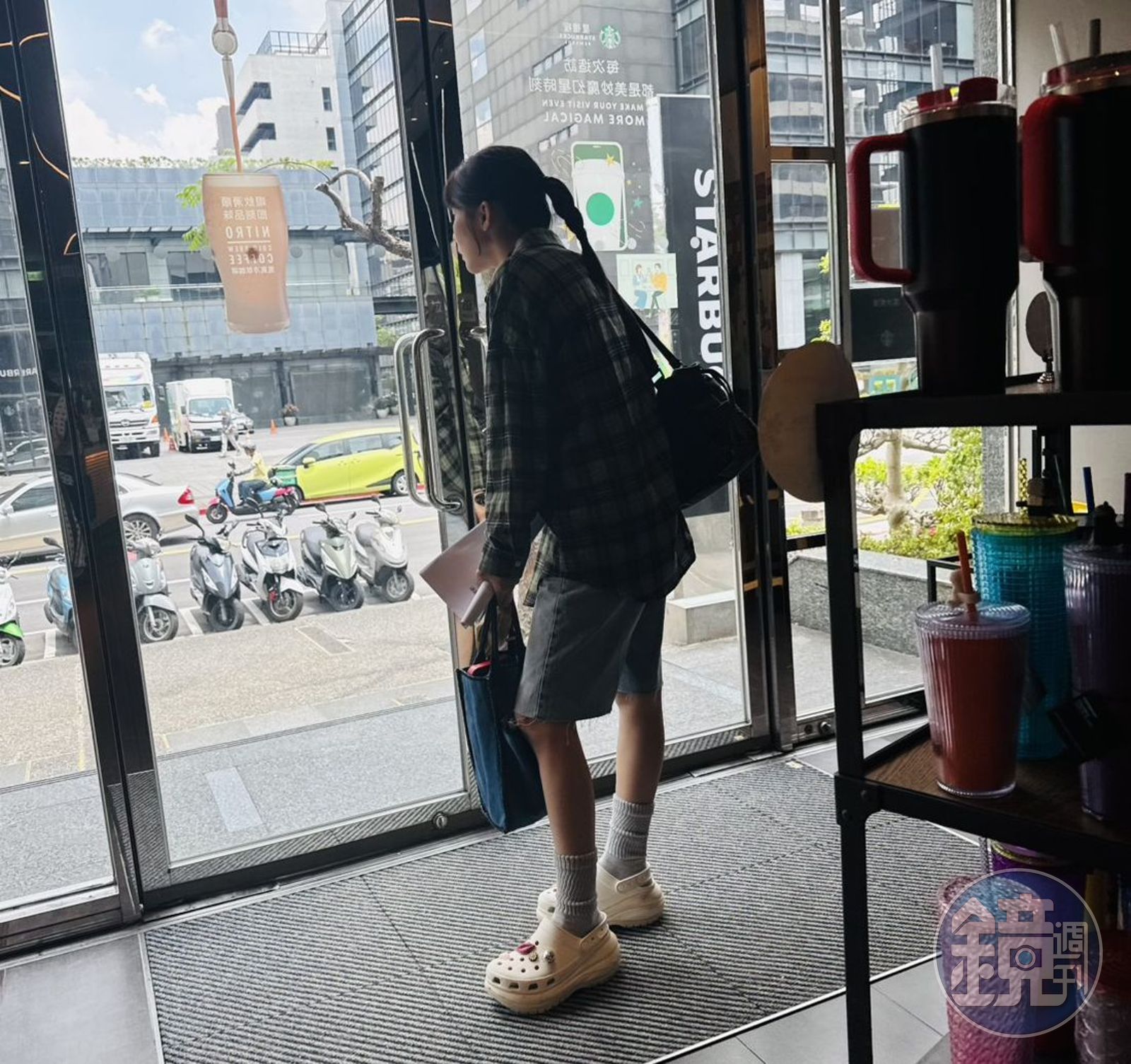 林萱瑜邊等咖啡邊探頭看門外。（讀者提供）