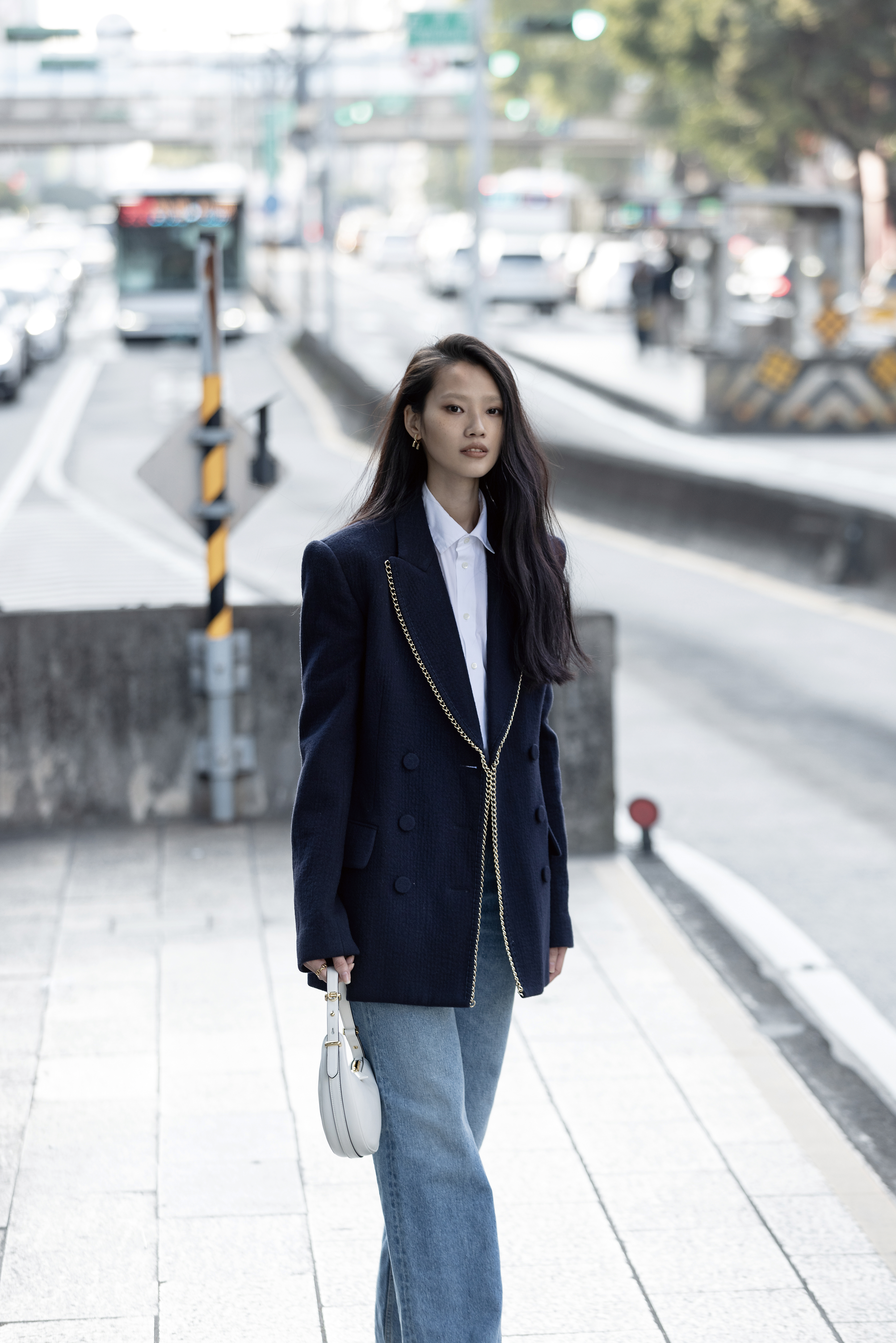 深藍色鍊帶飾邊外套 價格店洽 by Chloé／白色襯衫 NT$51,000 by Dior／丹寧褲 NT$39,900 by Chloé／Marcie金色耳環 NT$12,800 by Chloé／Arqué皮革肩背包 NT$86,000 by PRADA