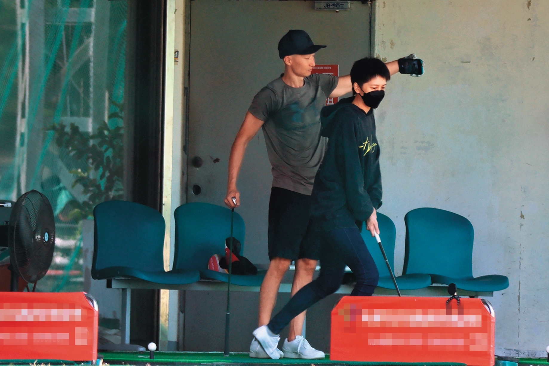 12/11 13：21，劉奕兒（右）與男友洪天祥（左）來到高爾夫球場練習，兩人一個穿厚帽T，一個T恤短褲，好像分別過冬天以及夏天。