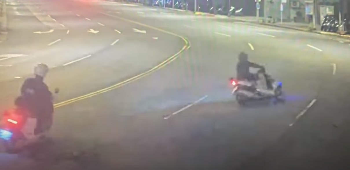 廖男騎車闖紅燈，見警上前追人，還囂張比中指，結果下一秒就自撞路邊鐵柱。（翻攝畫面）