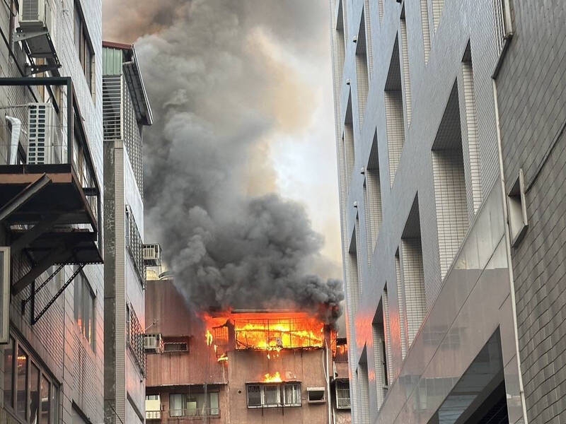 警消人員抵達時，成功路巷弄內這棟集合式住宅5樓與6樓加蓋鐵皮屋，已經完全陷入火海。（翻攝畫面）