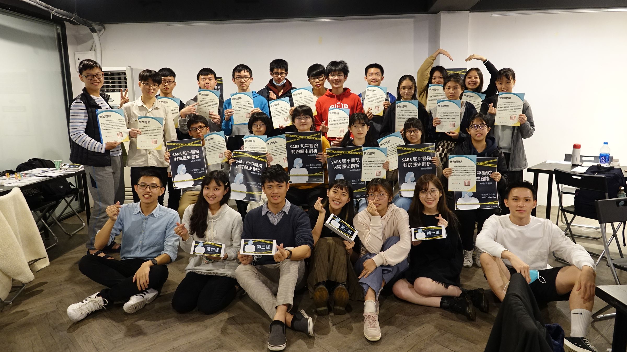 醫起玩工作室到師大附中舉行桌遊工作坊,成員周玄(前排左起)、陳姸妡、施泓誠、周奕伶、李怡臻、郭可盈、陳秉諄與學生們合照。 (醫起玩工作室提供)