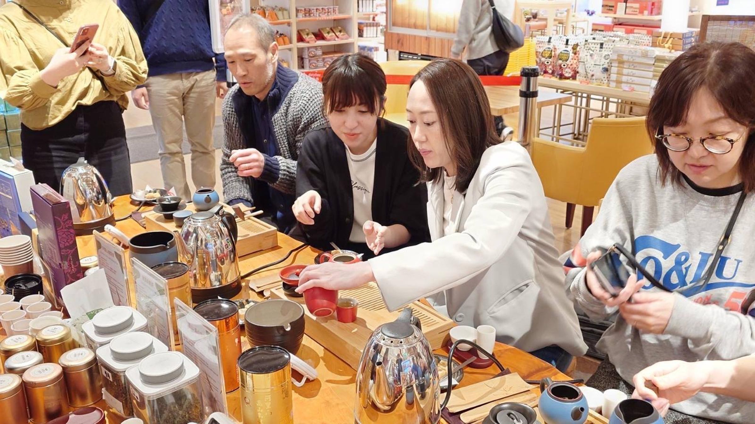 昇恆昌免稅商店在旅人入店後端上臺灣出品的熱茶、鳳梨酥,讓他們品嚐滿滿臺灣味,感受臺灣溫暖。(讀者提供)