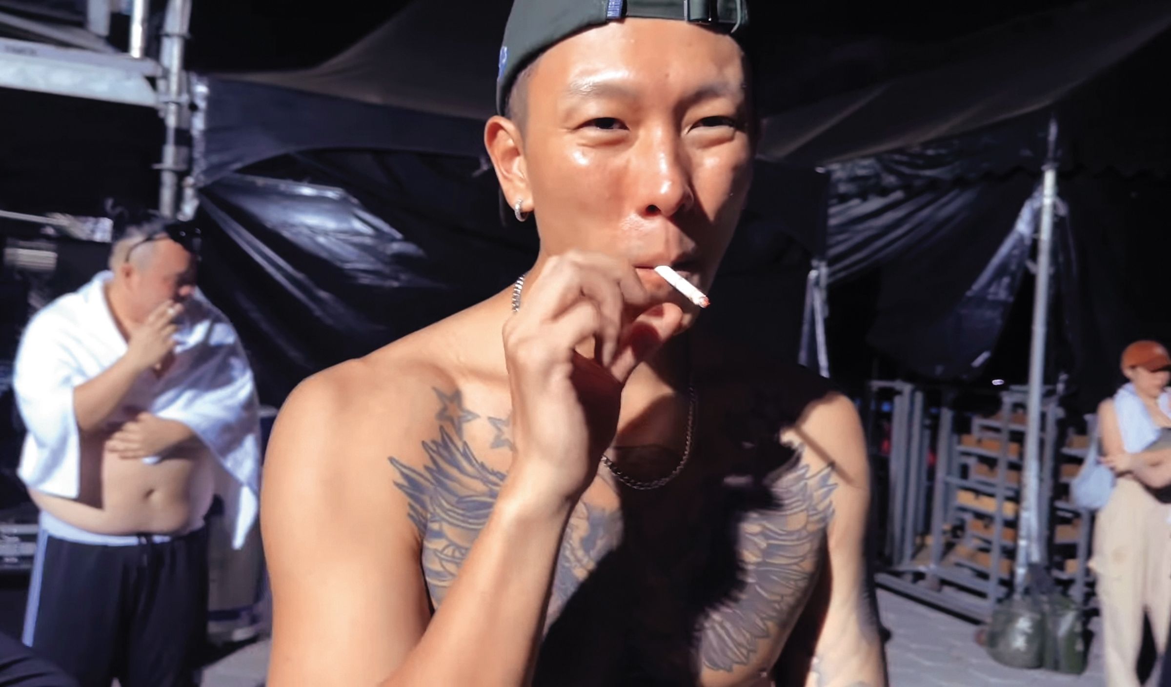 在演出後,瘦子(前)脫掉上衣在後台抽菸抒壓,後方的大淵(後)也在吞雲吐霧。(翻攝自本色音樂臉書)