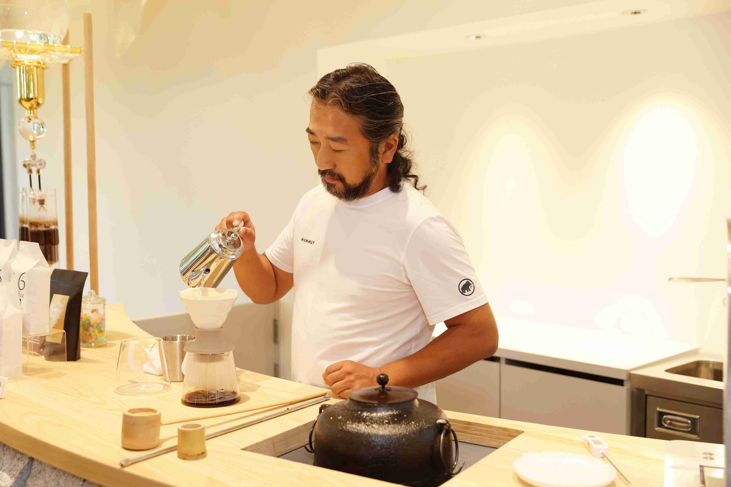 市川草介親自示範森彥式手沖咖啡,旁邊是煮水的陶甕。(薰衣草森林提供)